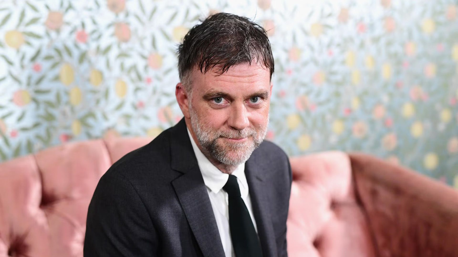 Reżyser Paul Thomas Anderson siedzi na różowej kanapie