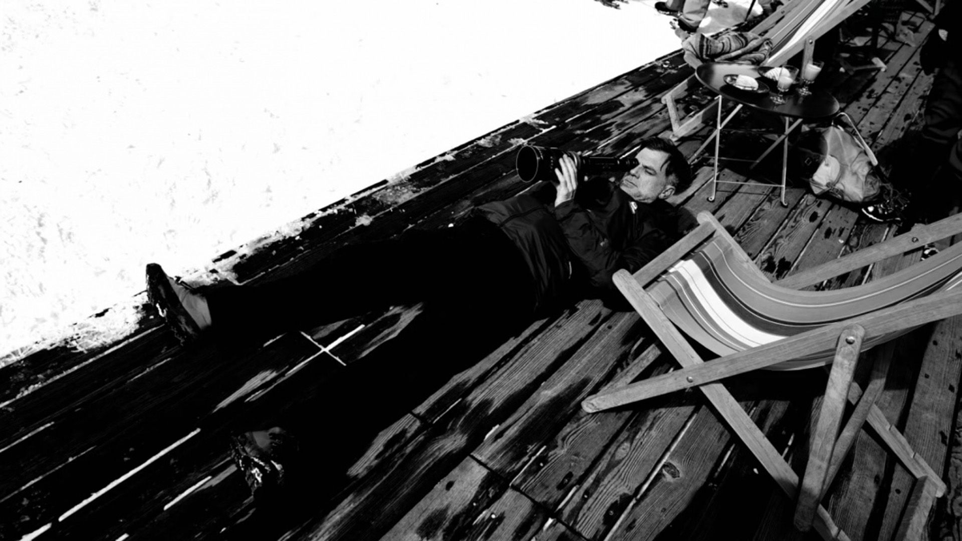 Paul Thomas Anderson leżący na podłodze, patrzący w obiektyw kamery
