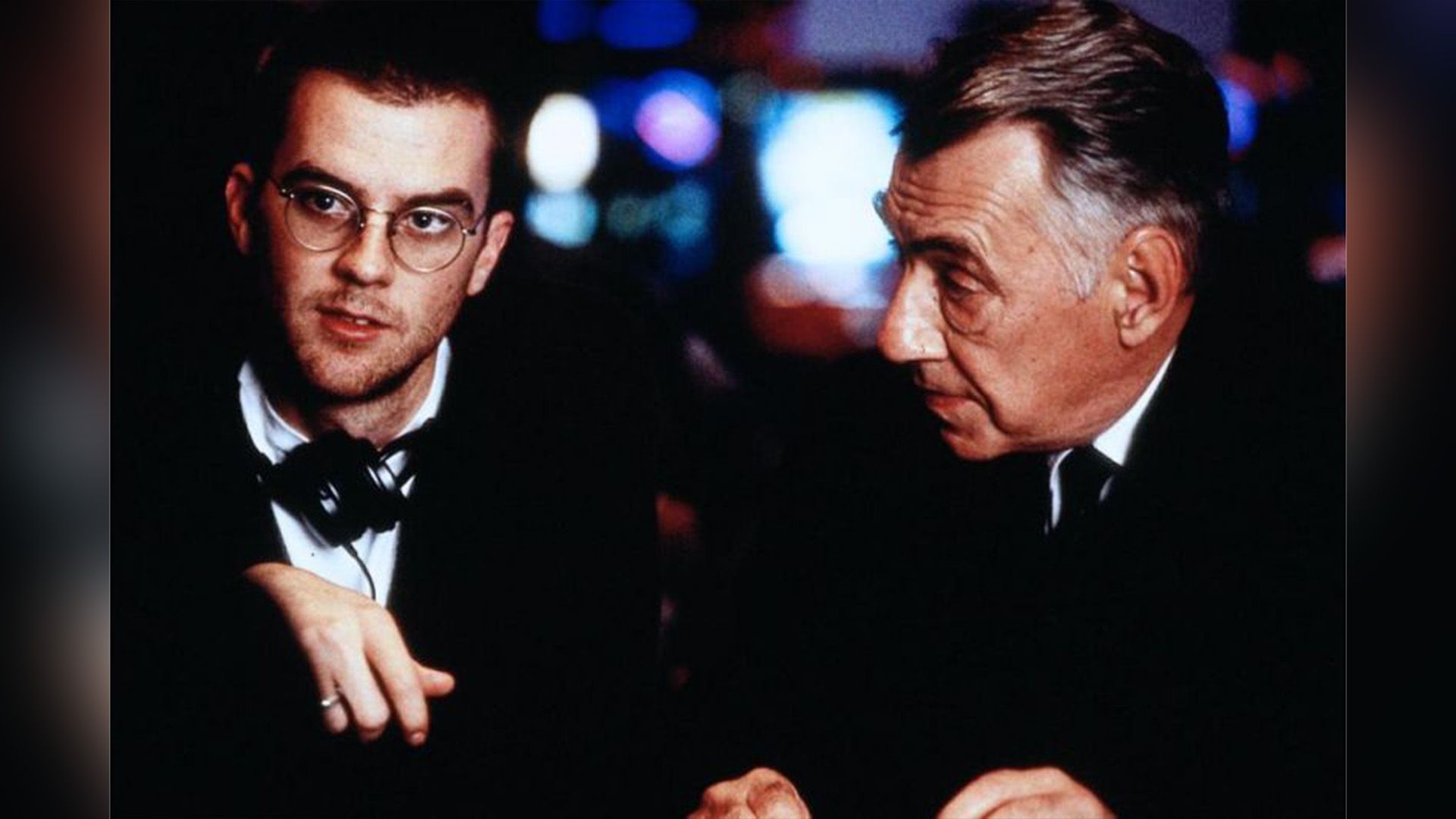 Paul Thomas Anderson w okularach ze słuchawkami na szyi i Philip Baker Hall