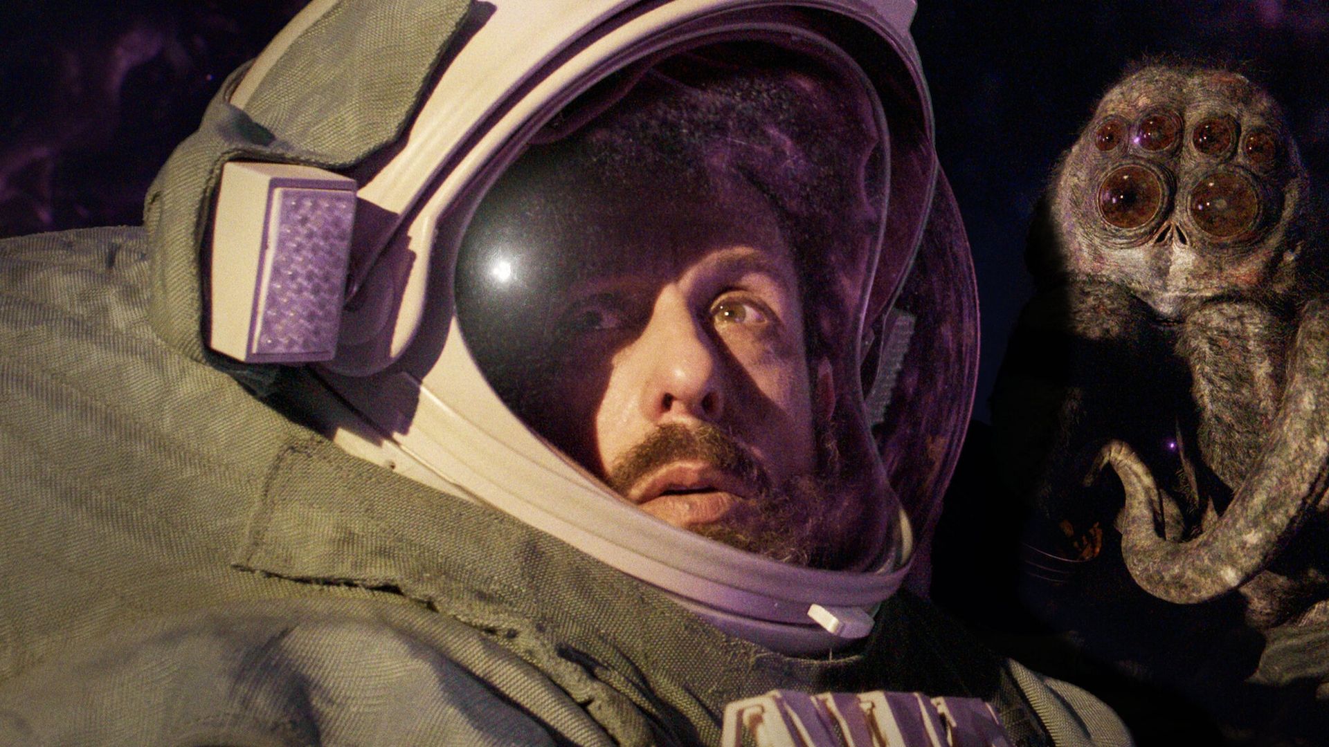 Adam Sandler w hełmie astronauty, po prawej stronie gigantyczny owad