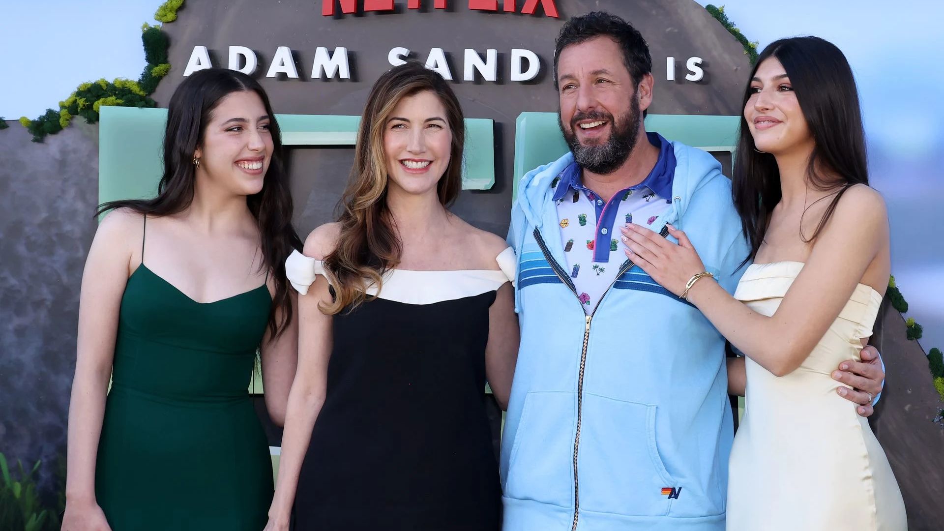Adam Sandler z żoną i dwiema córkami pozujący na tle ścianki Netflix