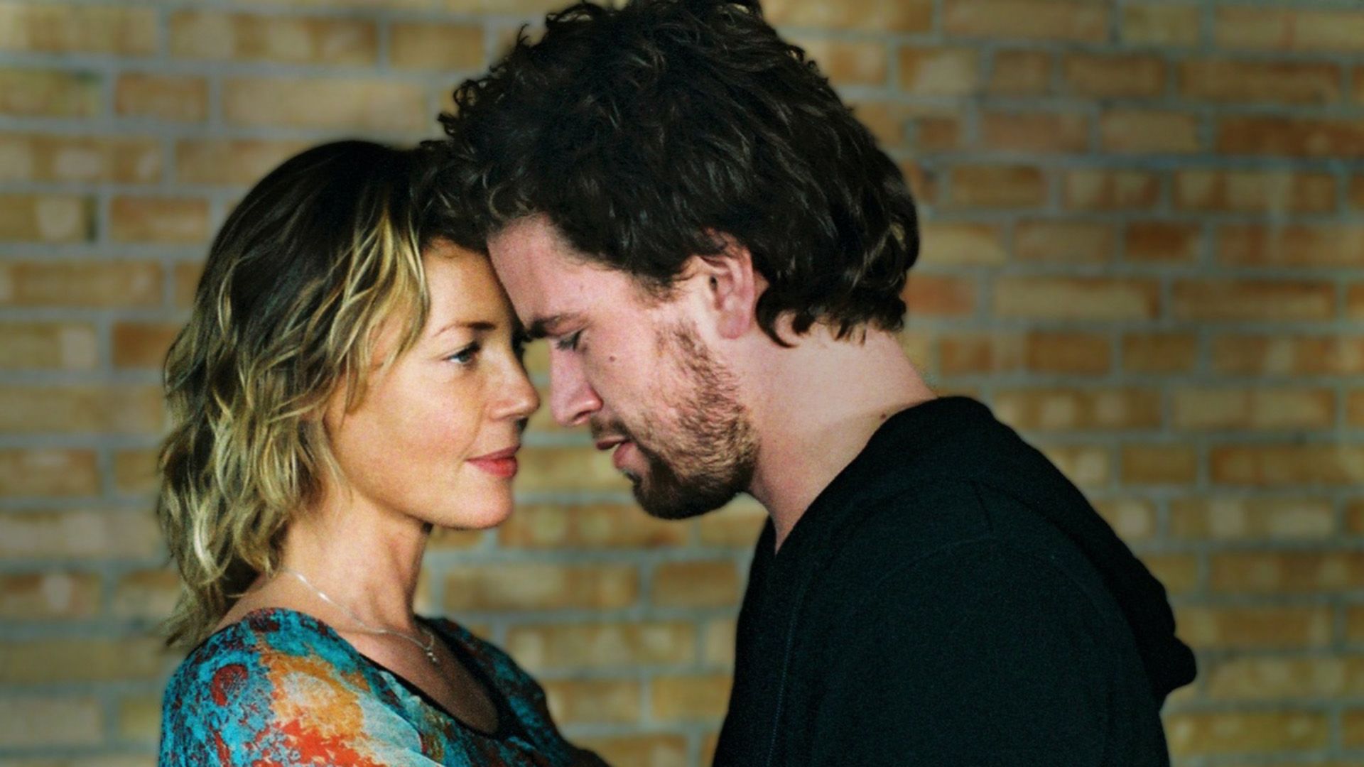 Connie Nielsen i ciemnowłosy mężczyzna przyciśnięci czołami do siebie