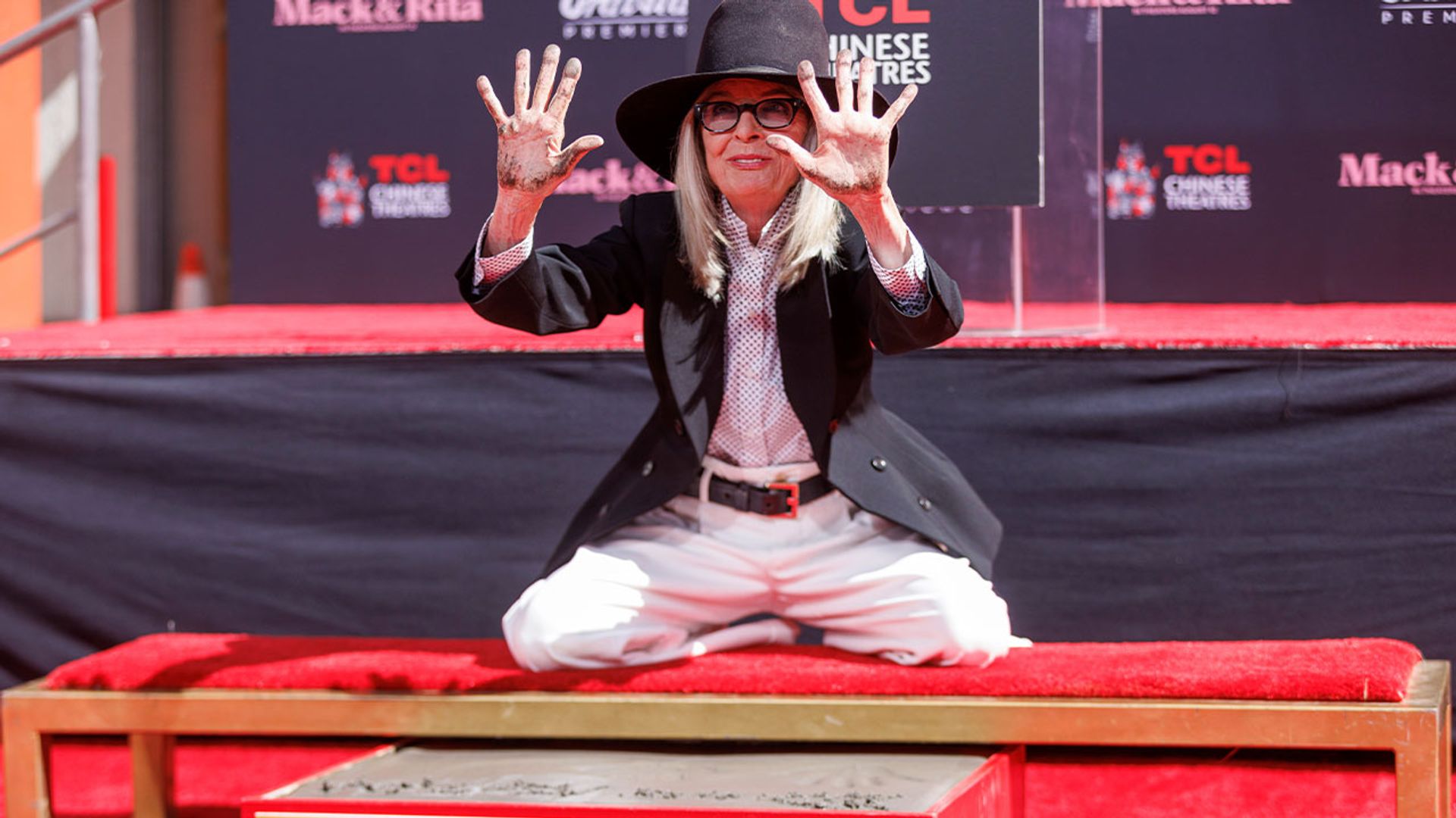 Diane Keaton w kapeluszu i garniturze zostawia odciski dłoni w betonie
