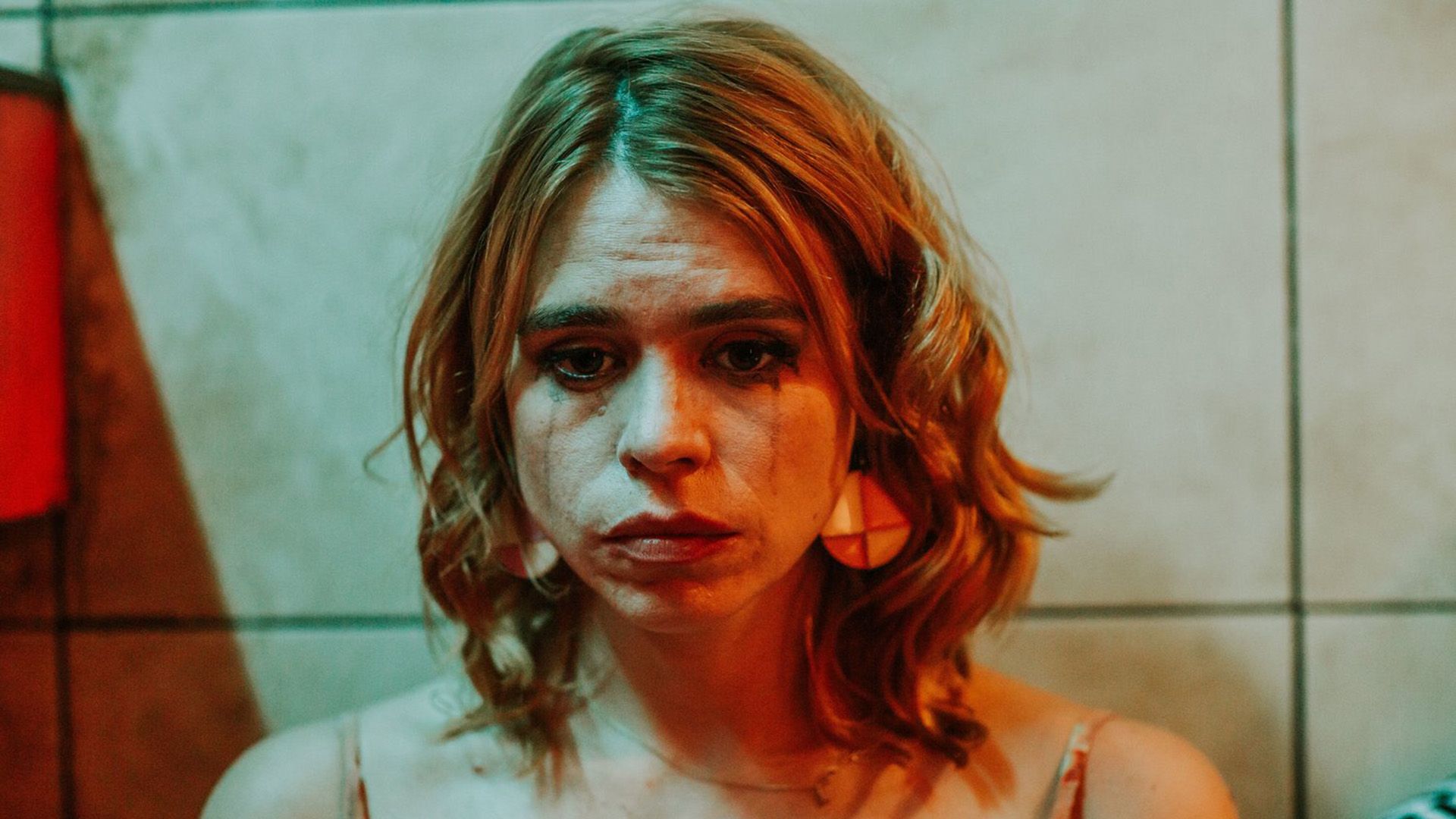Smutna Billie Piper z rozmazanym tuszem do rzęs, oświetlona czerwonym światłem