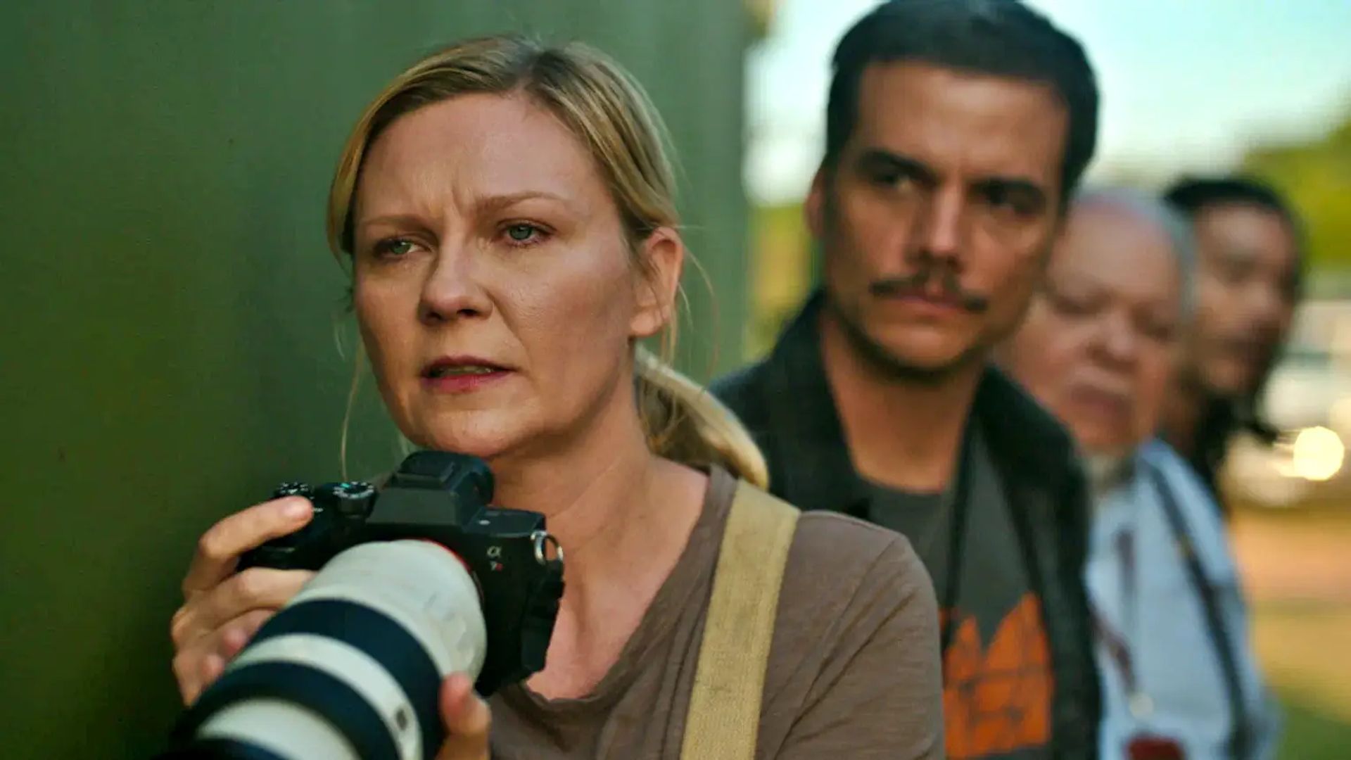 Kirsten Dunst trzyma aparat i patrzy naprzód z napięciem