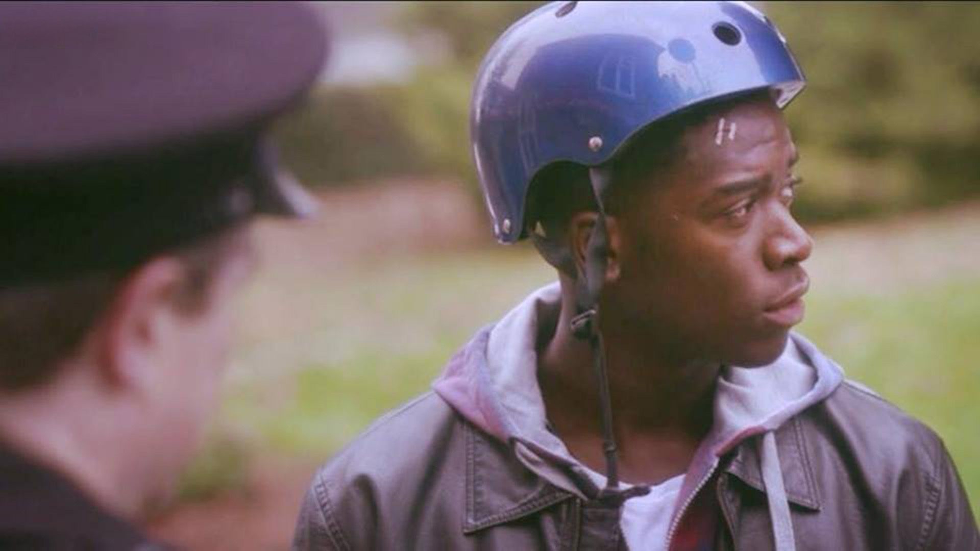 Damson Idris w kasku rowerowym, z profilu