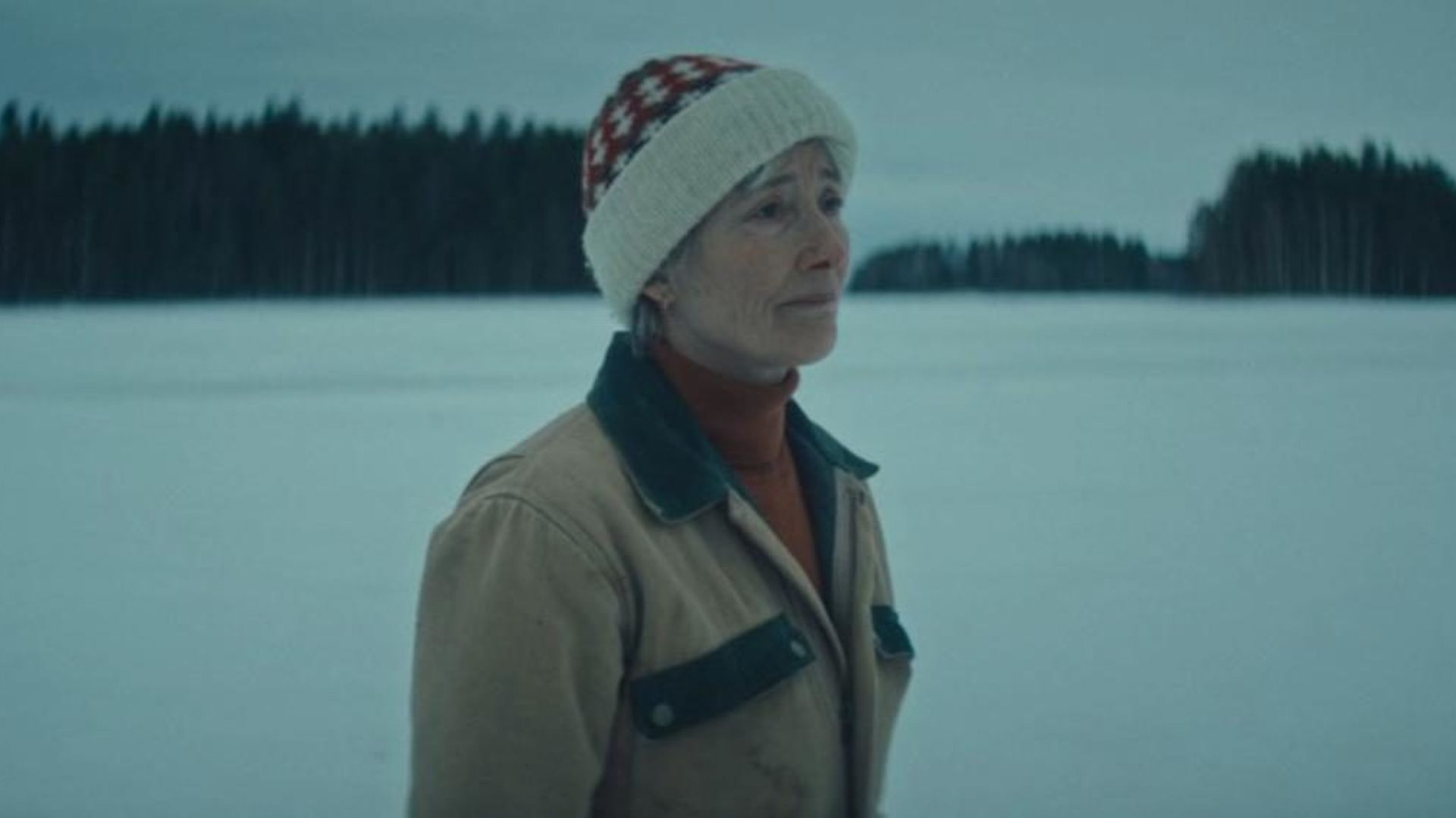 Emma Thompson w zimowym ubraniu na tle śnieżnego krajobrazu, zdjęcie w niebieskich tonach