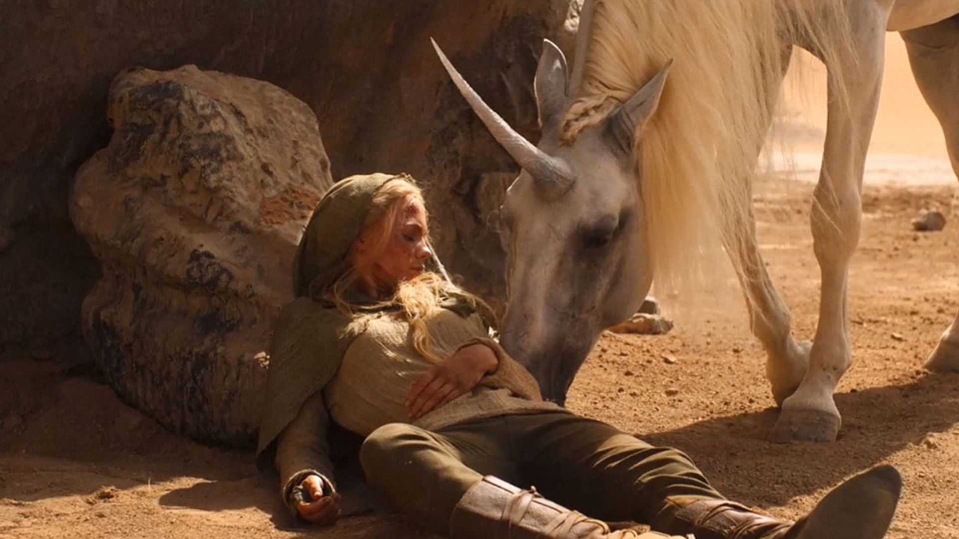 Freya Allan głaszcze konia z rogiem, scena z serialu "The Witcher"