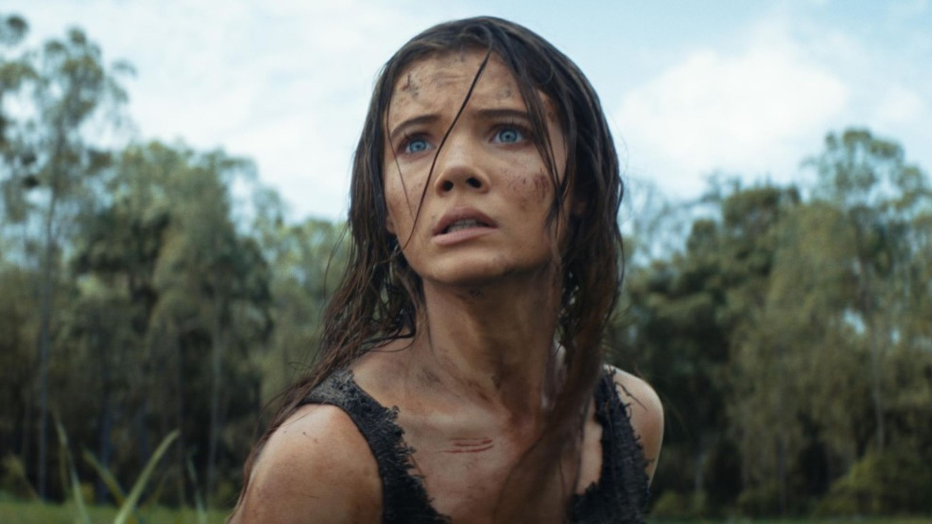 Freya Allan z potarganymi włosami i zabrudzoną twarzą patrzy niespokojnie w dal