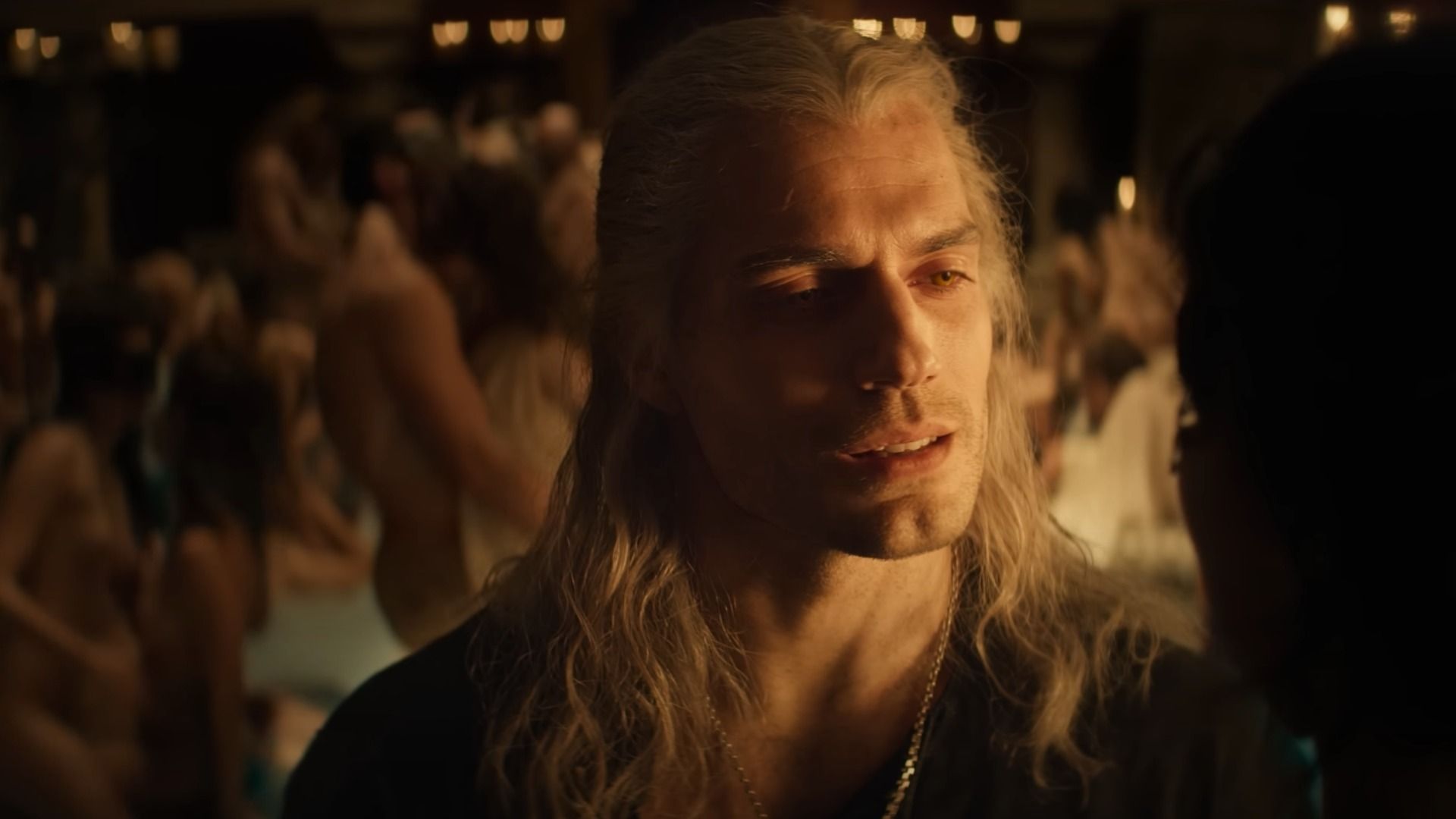 Aktor Henry Cavill z długimi białymi włosami w czarnym ubraniu