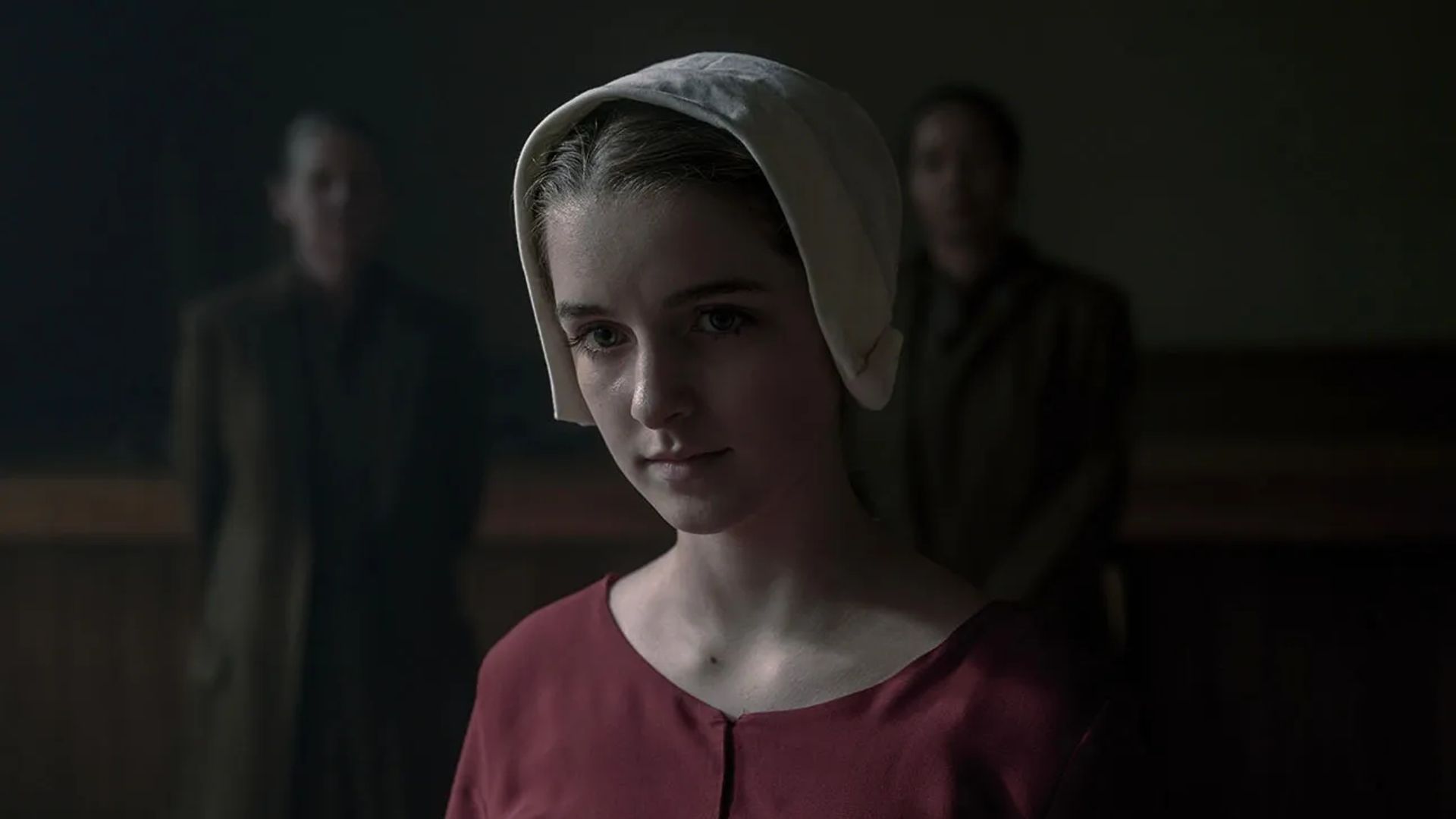 Mckenna Grace w czepku i kostiumie z epoki, kadr z serialu The Handmaid's Tale
