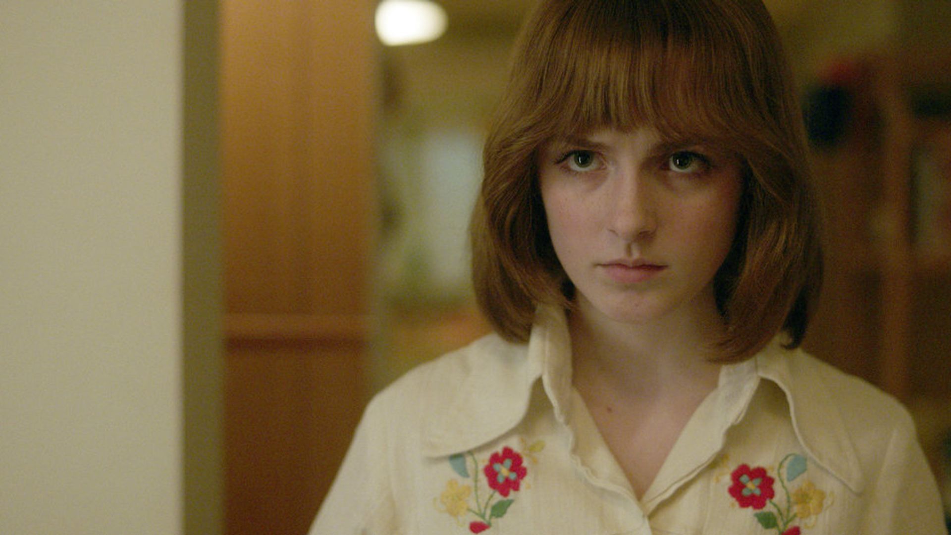 Mckenna Grace z rudym bobem i modą lat 80., scena z miniserialu