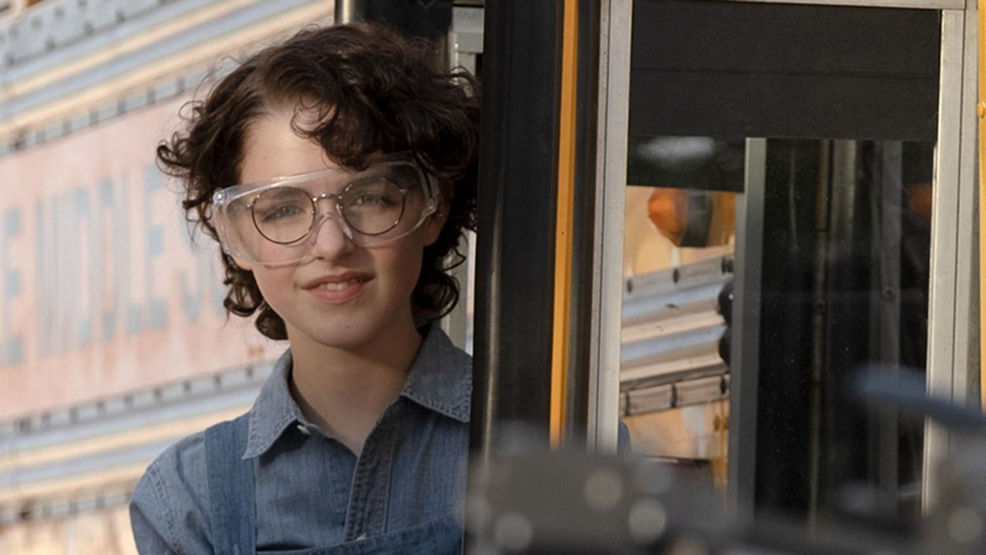 Mckenna Grace z krótkimi czarnymi lokami i okularami, kadr z filmu