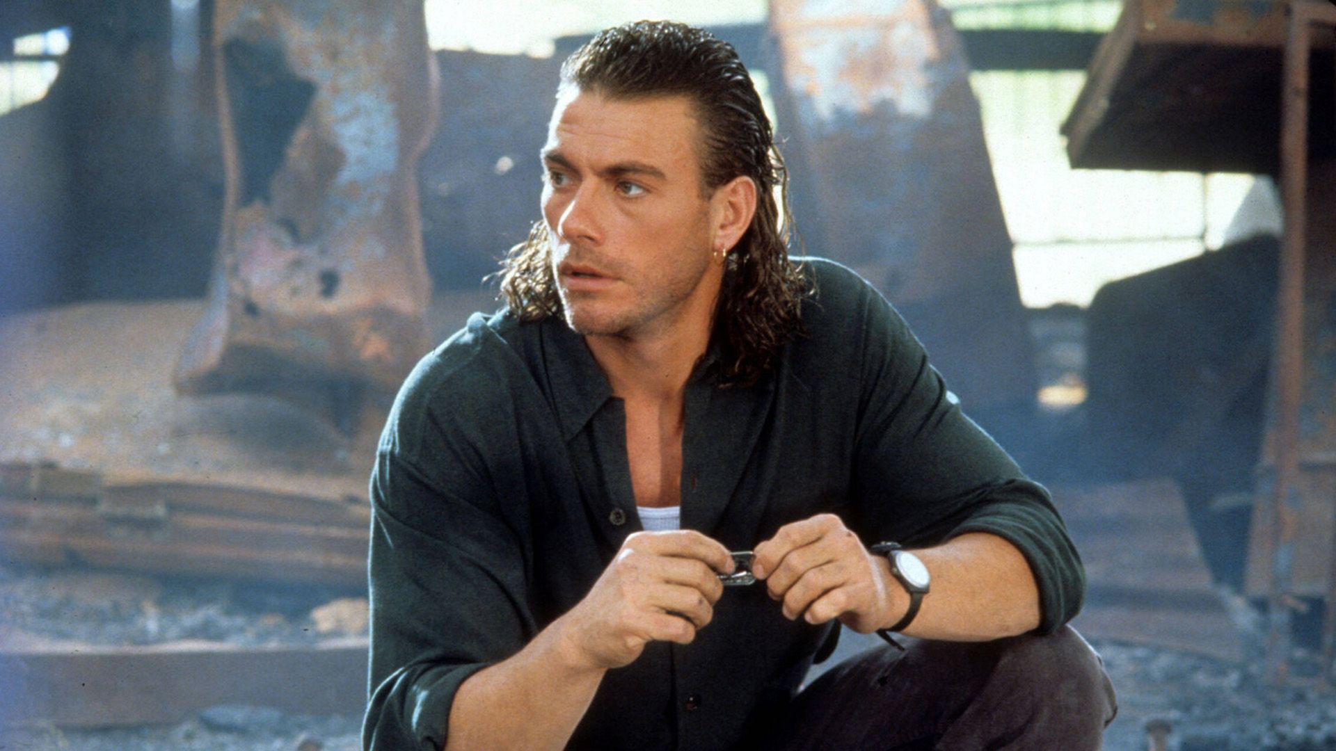 Młody Jean-Claude Van Damme z długimi włosami patrzący w bok