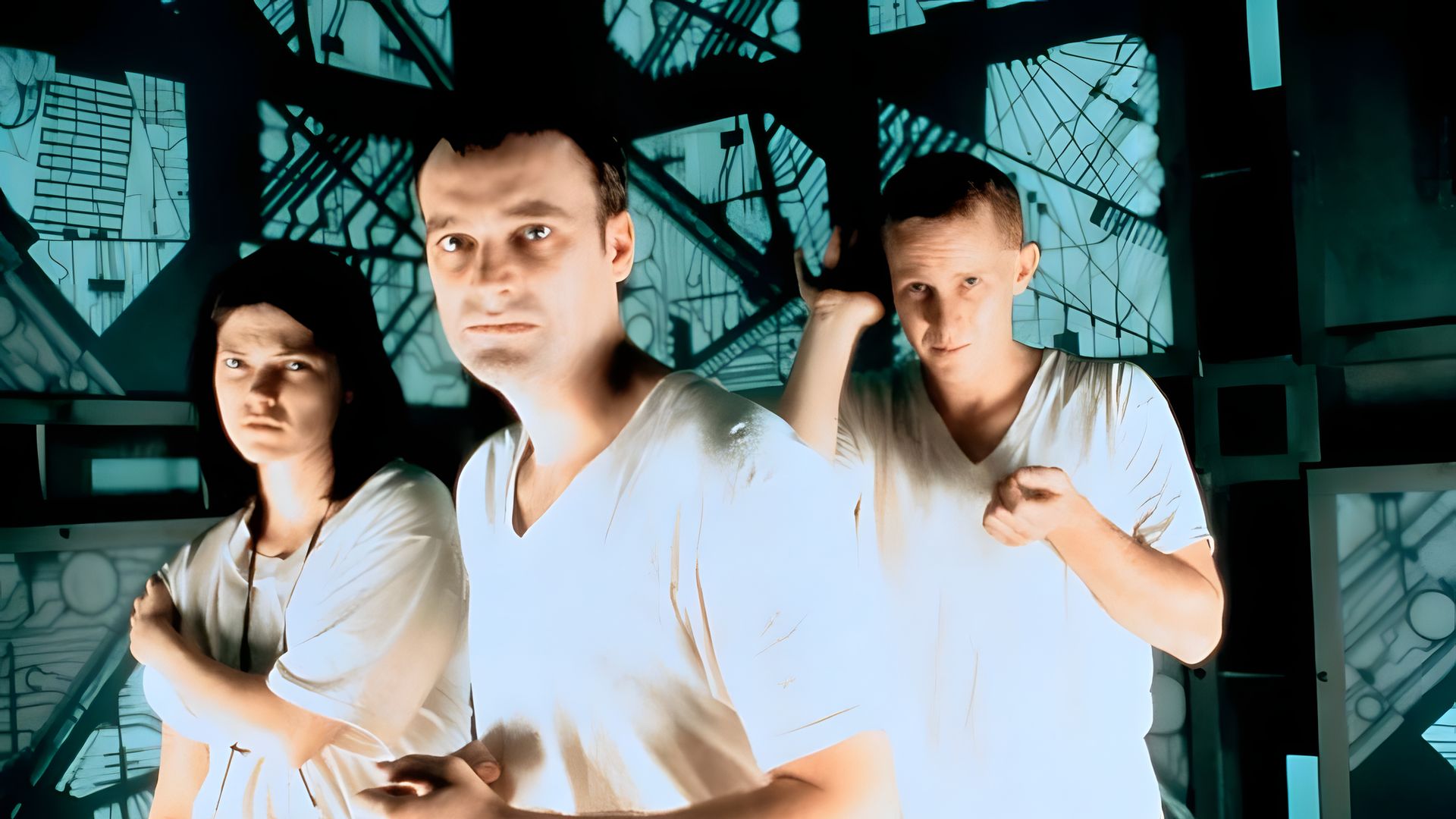 Three people in white clothing are standing in a futuristic room with mysterious patterns on the walls, looking tense