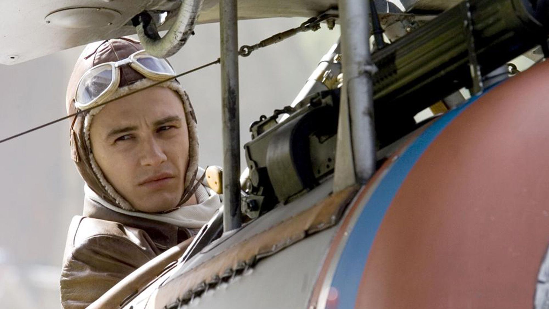 James Franco w mundurze pilota z I wojny światowej obok wojskowego samolotu