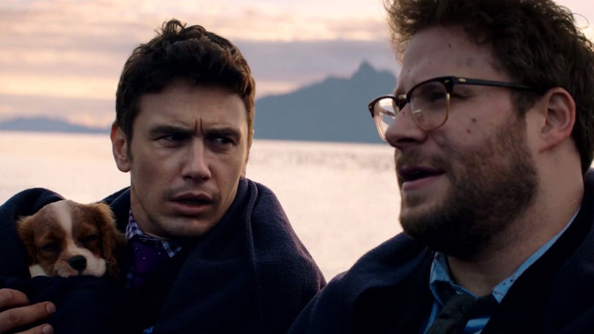 James Franco z szczeniakiem na rękach patrzy na Setha Rogena