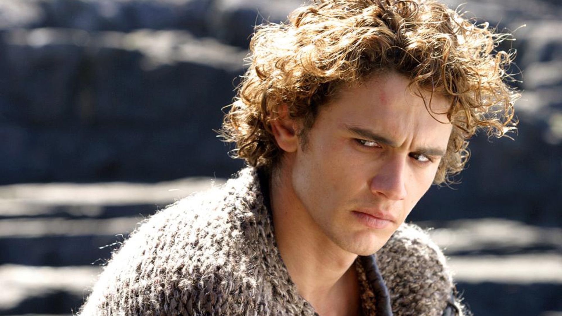 James Franco z złotymi lokami, patrzy ponuro w bok
