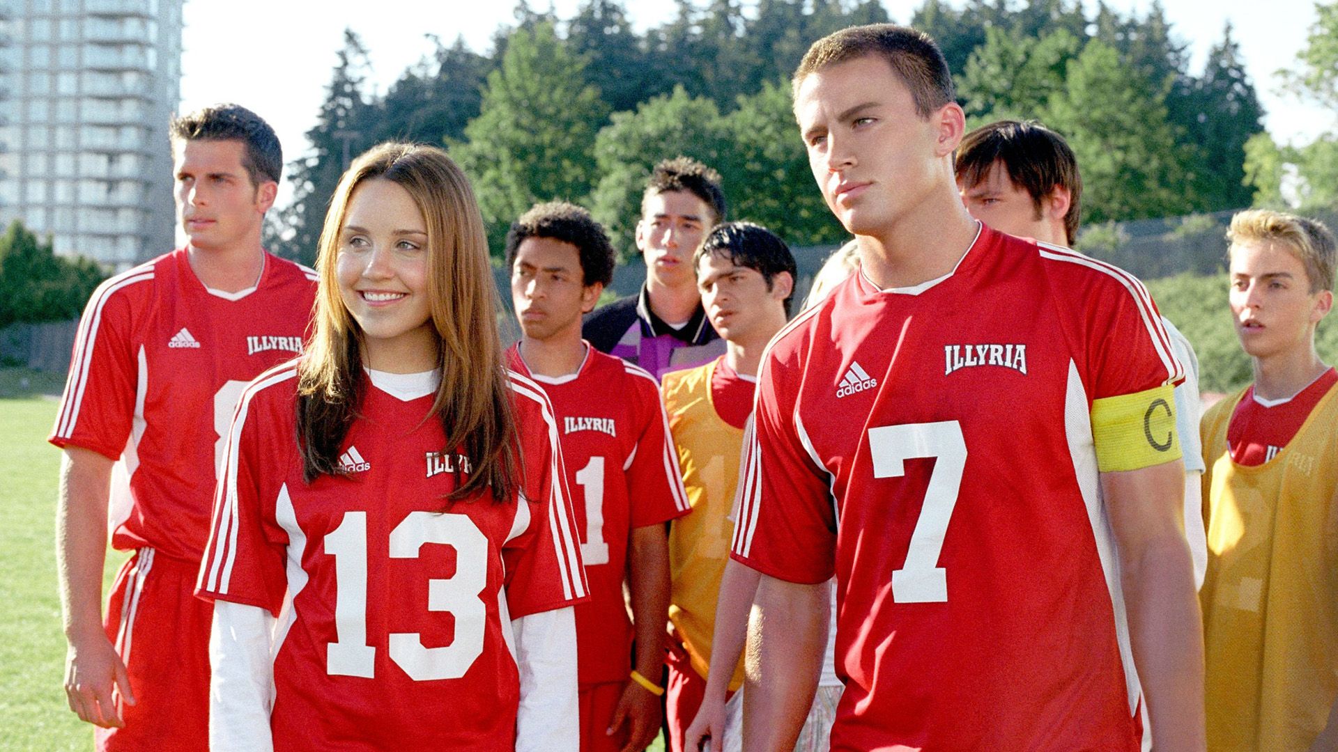 Amanda Bynes i Channing Tatum w czerwonych sportowych koszulkach otoczeni przez innych młodych ludzi