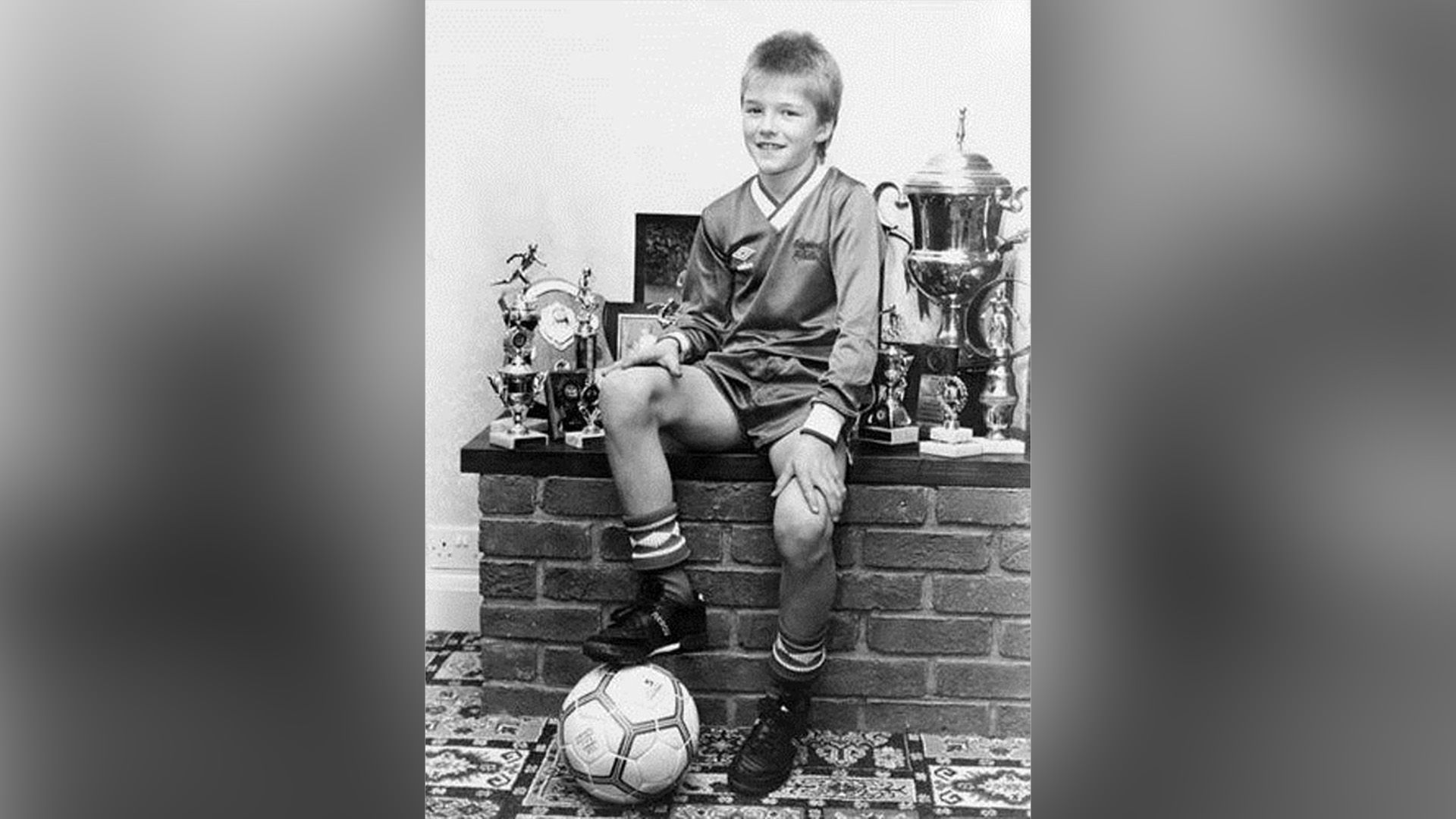 David Beckham jako dziecko w stroju piłkarskim i z piłką