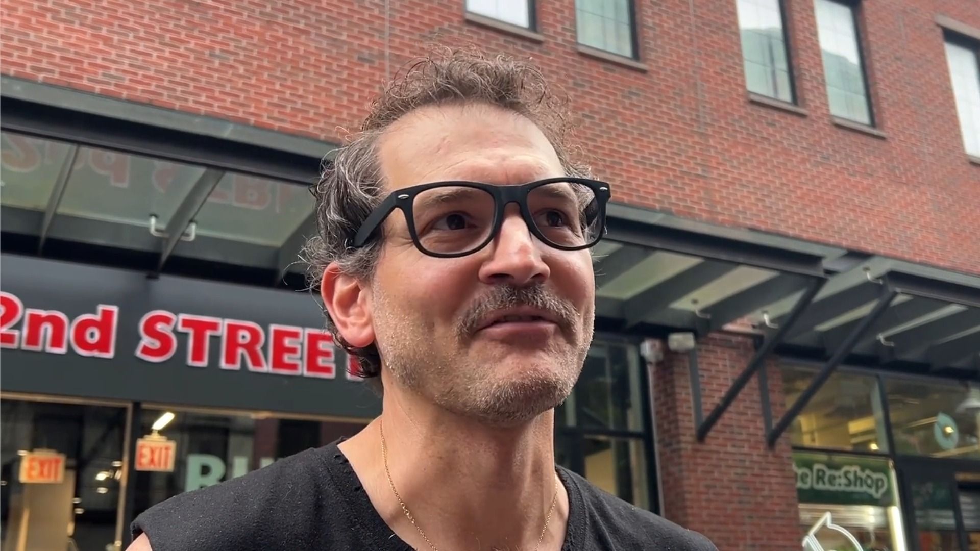George Guntas, technik oświetlenia w The Daily Show, w czarnym podkoszulku i okularach