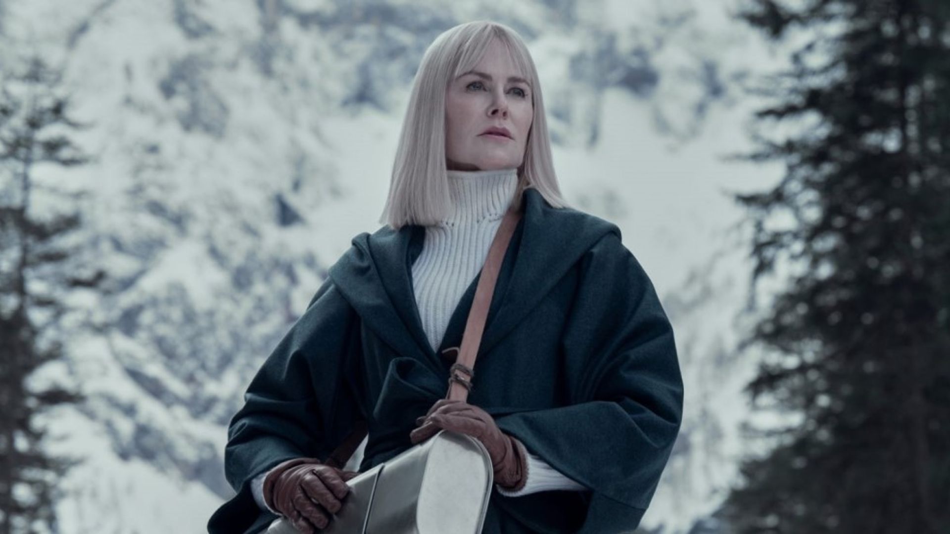 Nicole Kidman z prostymi białymi włosami w czarnym skórzanym płaszczu i białym swetrze