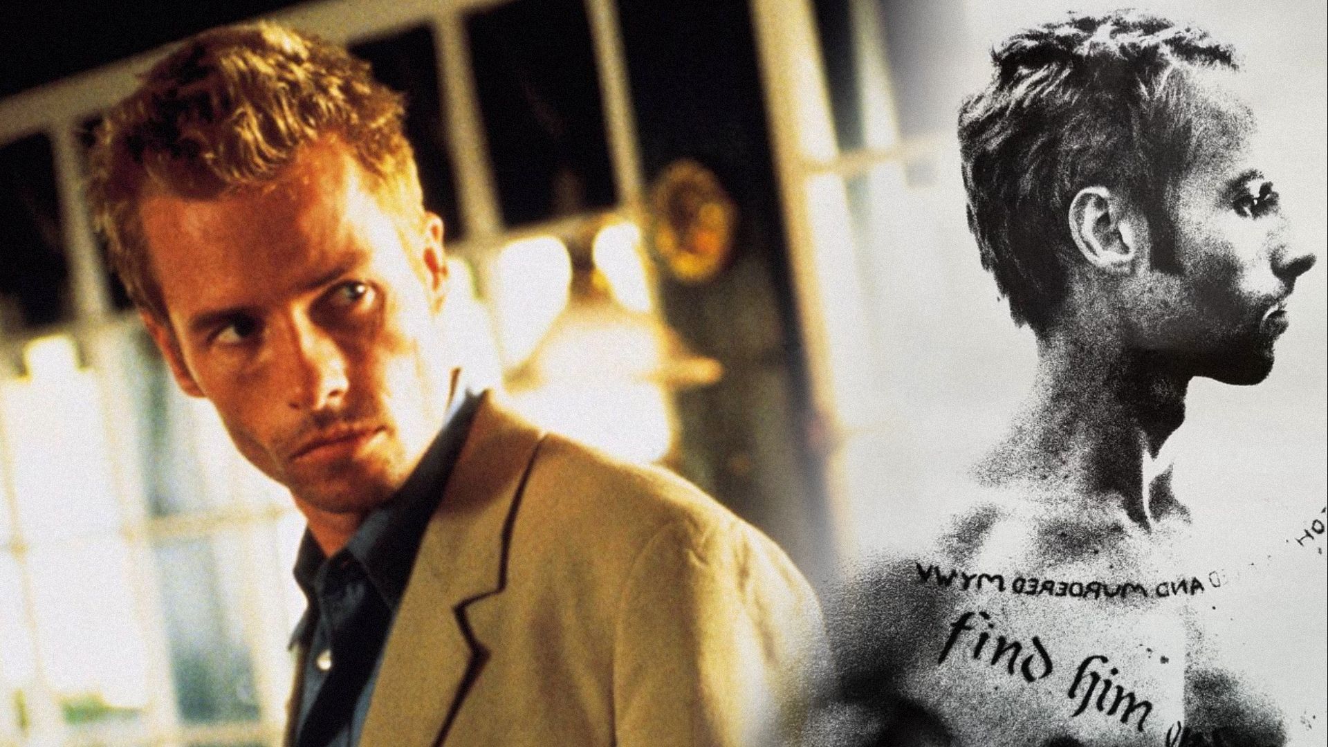 Aktor Guy Pearce w beżowej kurtce stojący w trzech czwartych, obok plakatu filmowego, gdzie aktor ma tatuaże na ciele