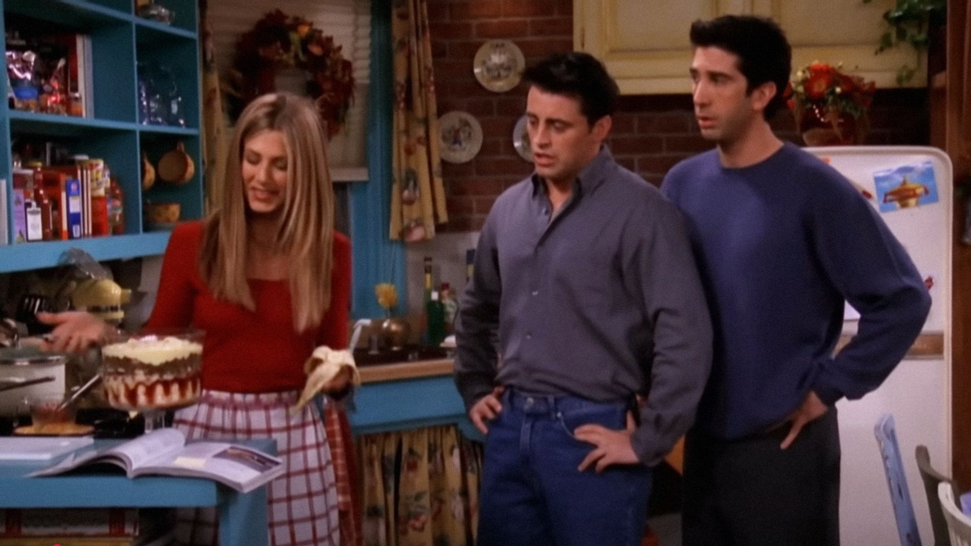 Aktorzy Jennifer Aniston, David Schwimmer i Matt LeBlanc patrzą na przezroczyste naczynie do pieczenia z zapiekanką