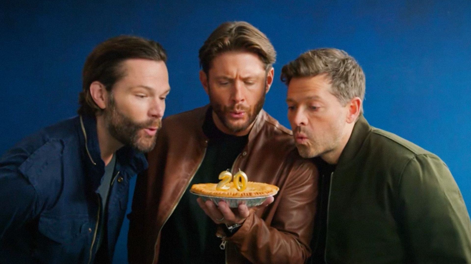 Aktorzy Jared Padalecki, Jensen Ackles i Misha Collins dmuchają świeczki na torcie