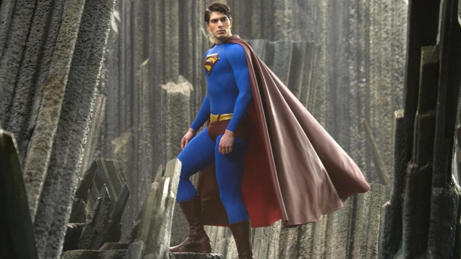 Aktor Brandon Routh w niebiesko-czerwonym kostiumie superbohatera z literą S na piersi wchodzi po schodach