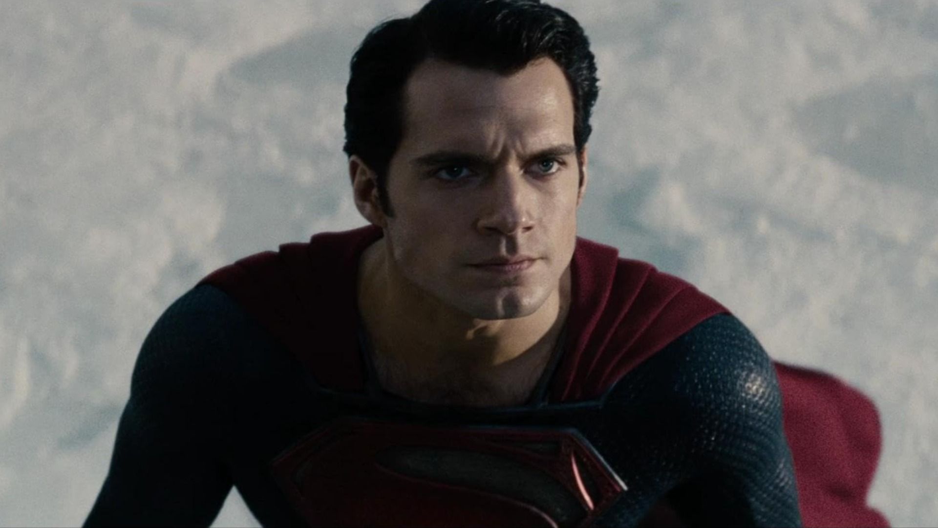 Aktor Henry Cavill w niebiesko-czerwonym kostiumie superbohatera z literą S na piersi