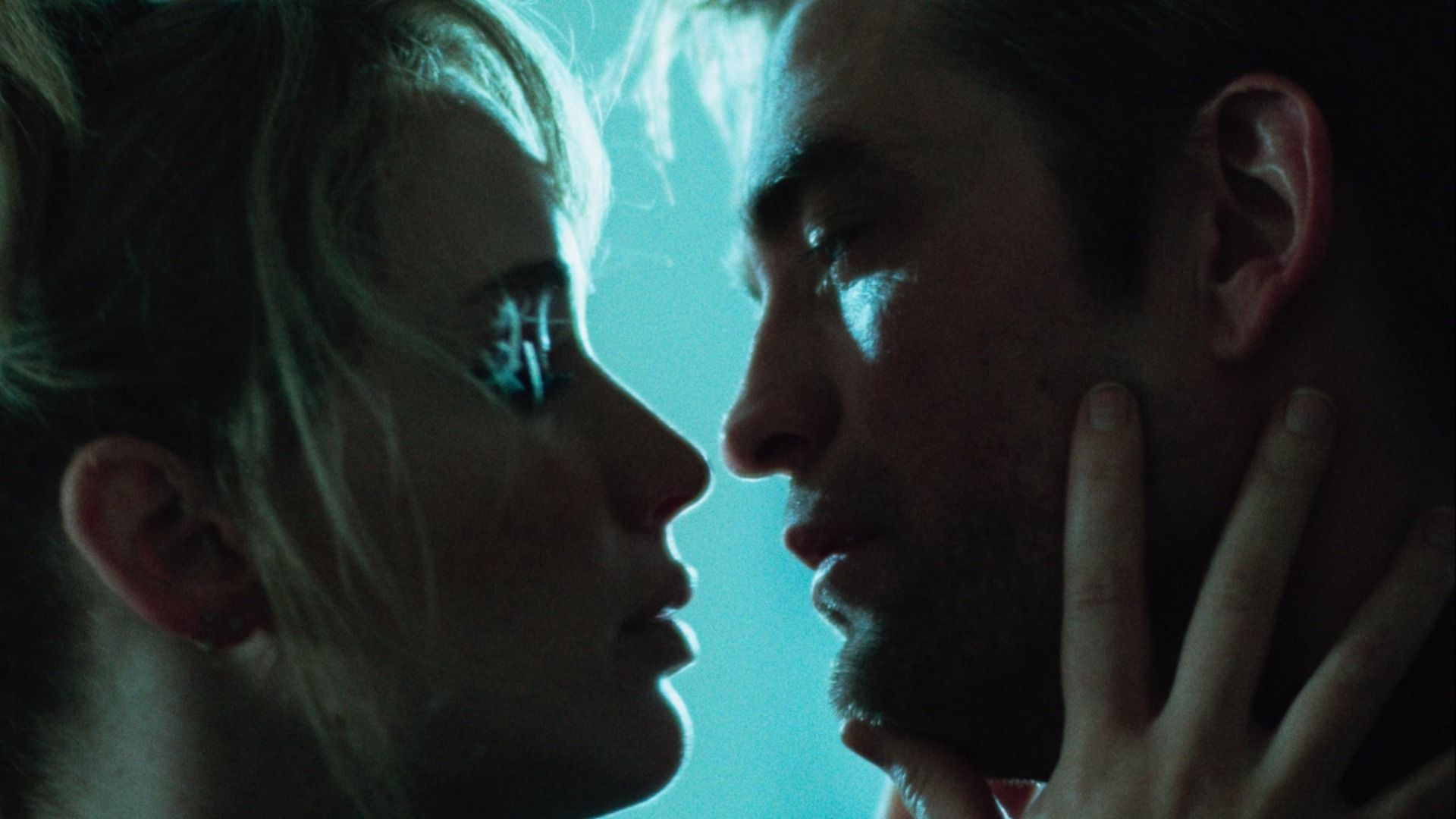 Aktorzy Jennifer Lawrence i Robert Pattinson patrzą sobie w oczy na niebieskim tle