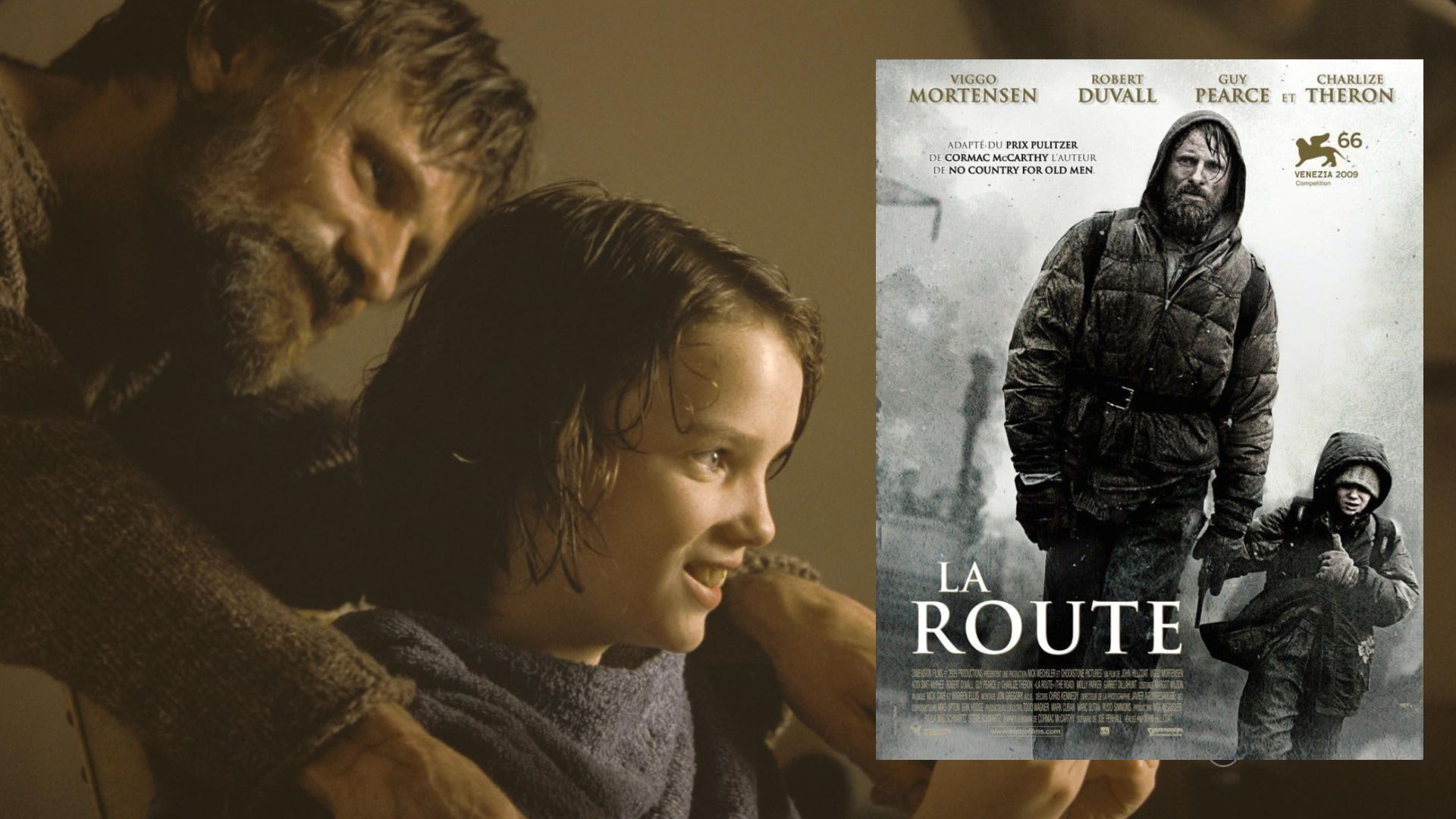 Aktor Viggo Mortensen w szarym swetrze siedzi obok dziecka, w pobliżu plakat filmowy pokazujący aktora idącego ulicą z dzieckiem
