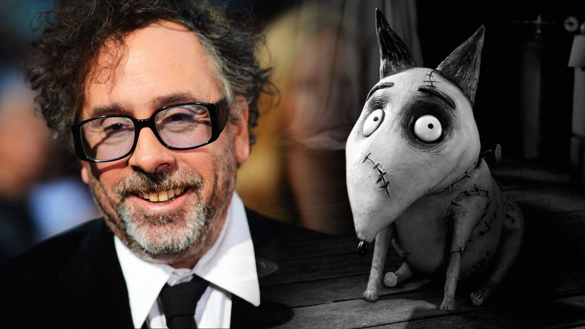 Reżyser Tim Burton w czarnej kurtce i okularach, z szarym psem obok niego