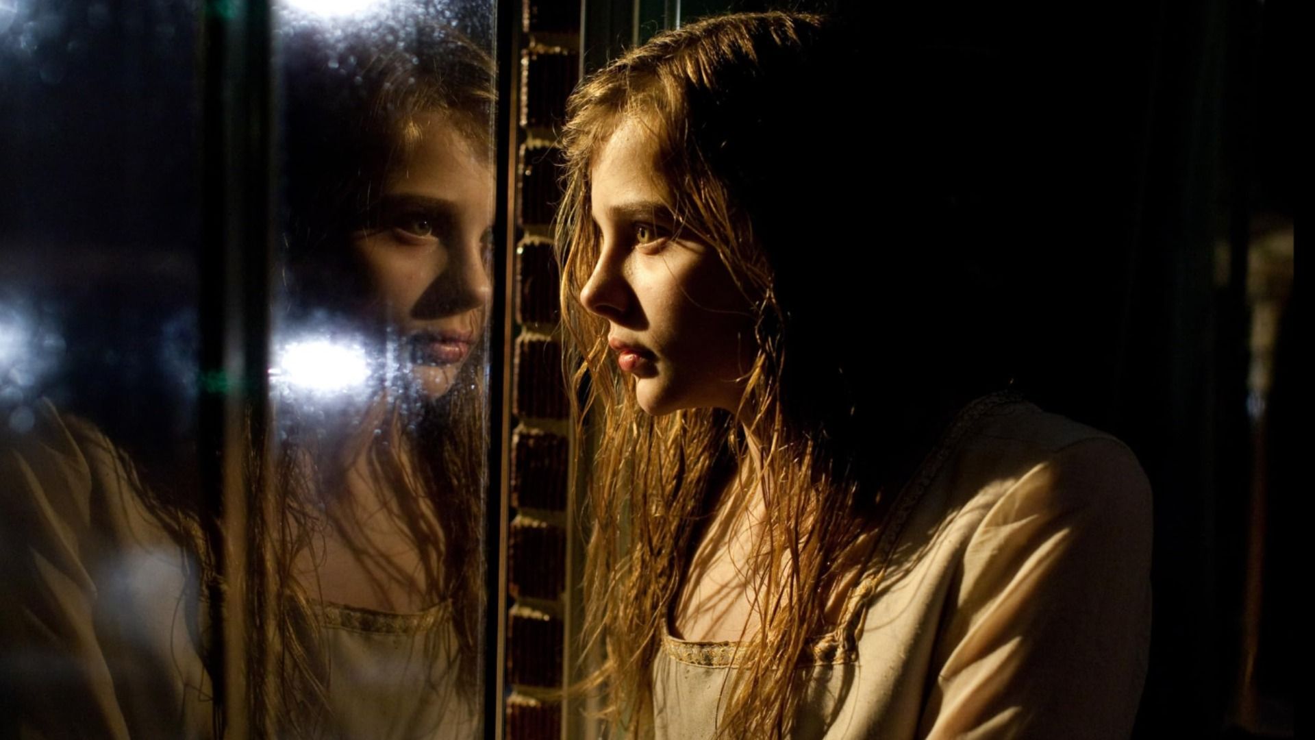 Aktorka Chloë Grace Moretz patrzy na swoje odbicie w oknie