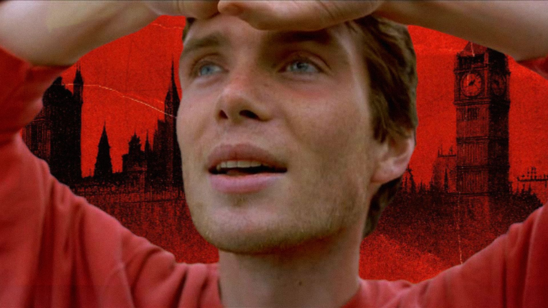 Aktor Cillian Murphy unosi ręce do głowy i uśmiecha się na tle londyńskiego panoramy w czerwonych tonach