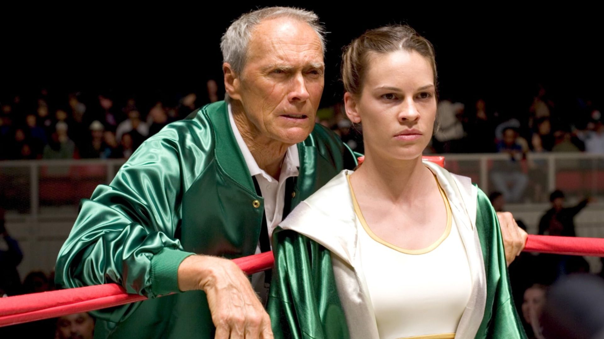 Aktorzy Clint Eastwood i Hilary Swank stoją w zielonych ubraniach na ringu bokserskim