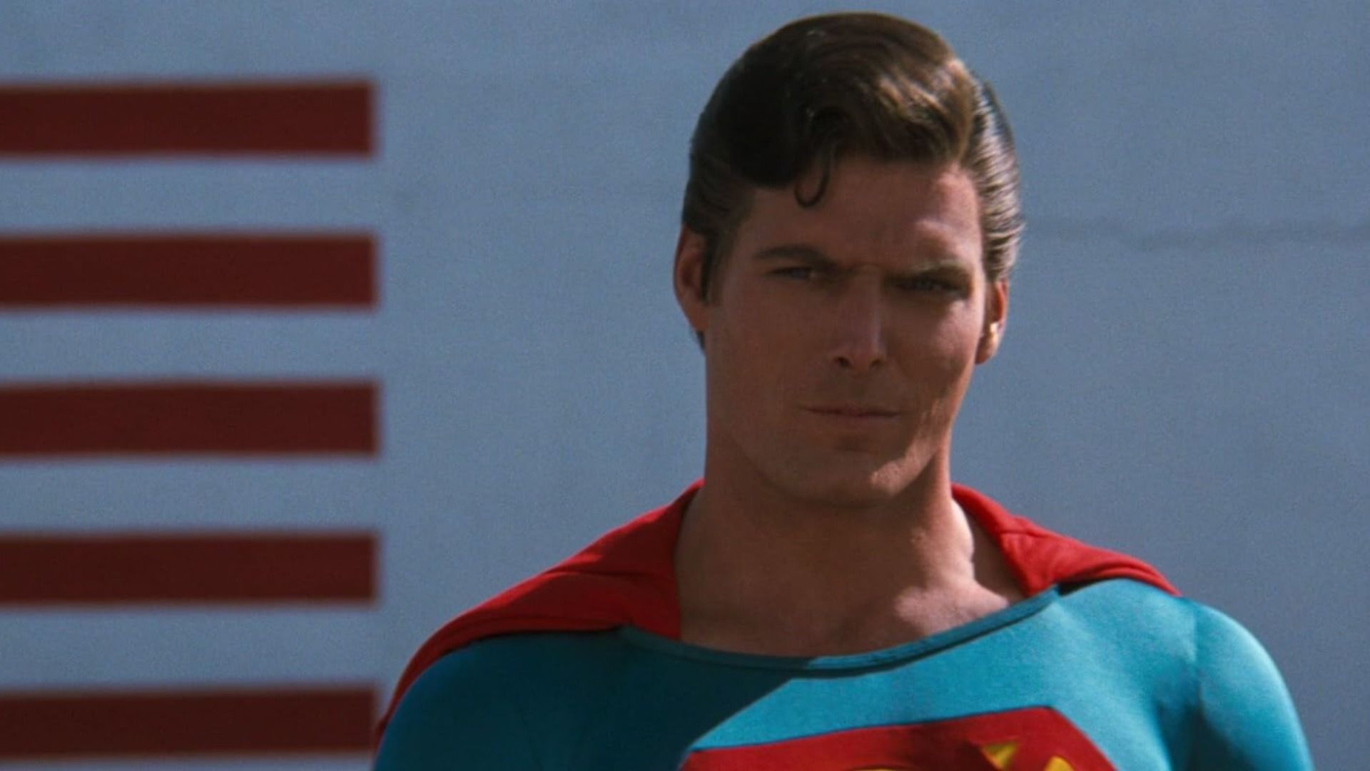 Aktor Christopher Reeve w niebiesko-czerwonym kostiumie Supermana spogląda groźnie w bok