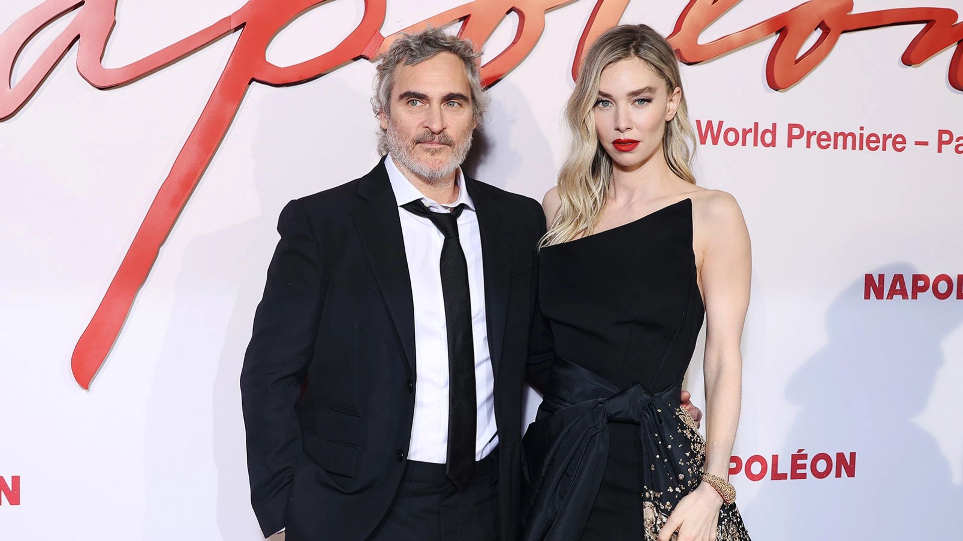 Joaquin Phoenix i Vanessa Kirby pozują na czerwonym dywanie podczas premiery filmu "Napoleon", oboje ubrani w eleganckie czarne stroje