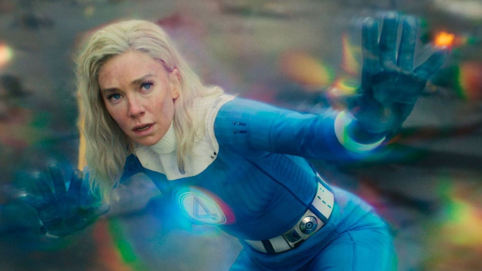 Vanessa Kirby w kostiumie Fantastycznej Czwórki używa swojej supermocy z tęczowymi energiami świecącymi wokół niej