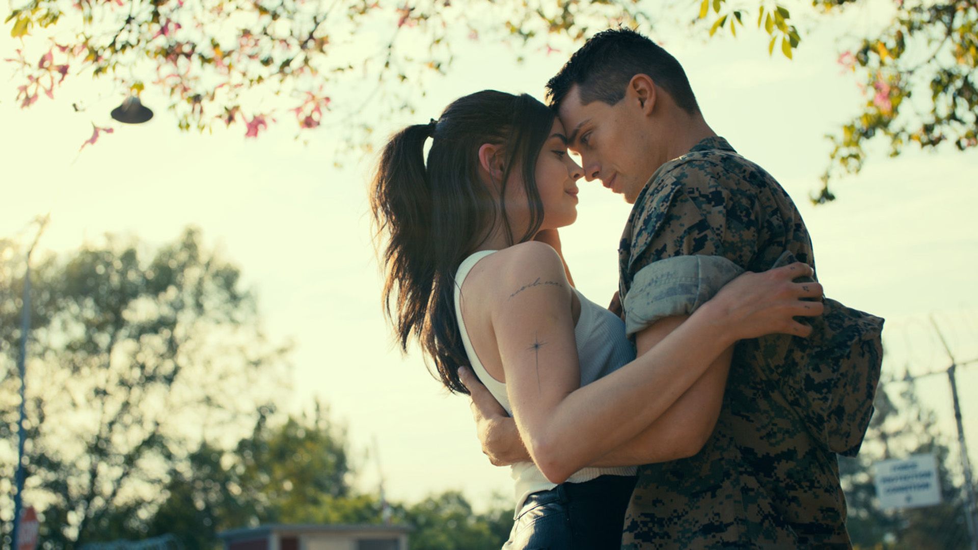 Sofia Carson i Nicholas Galitzine obejmują się stojąc pod drzewem