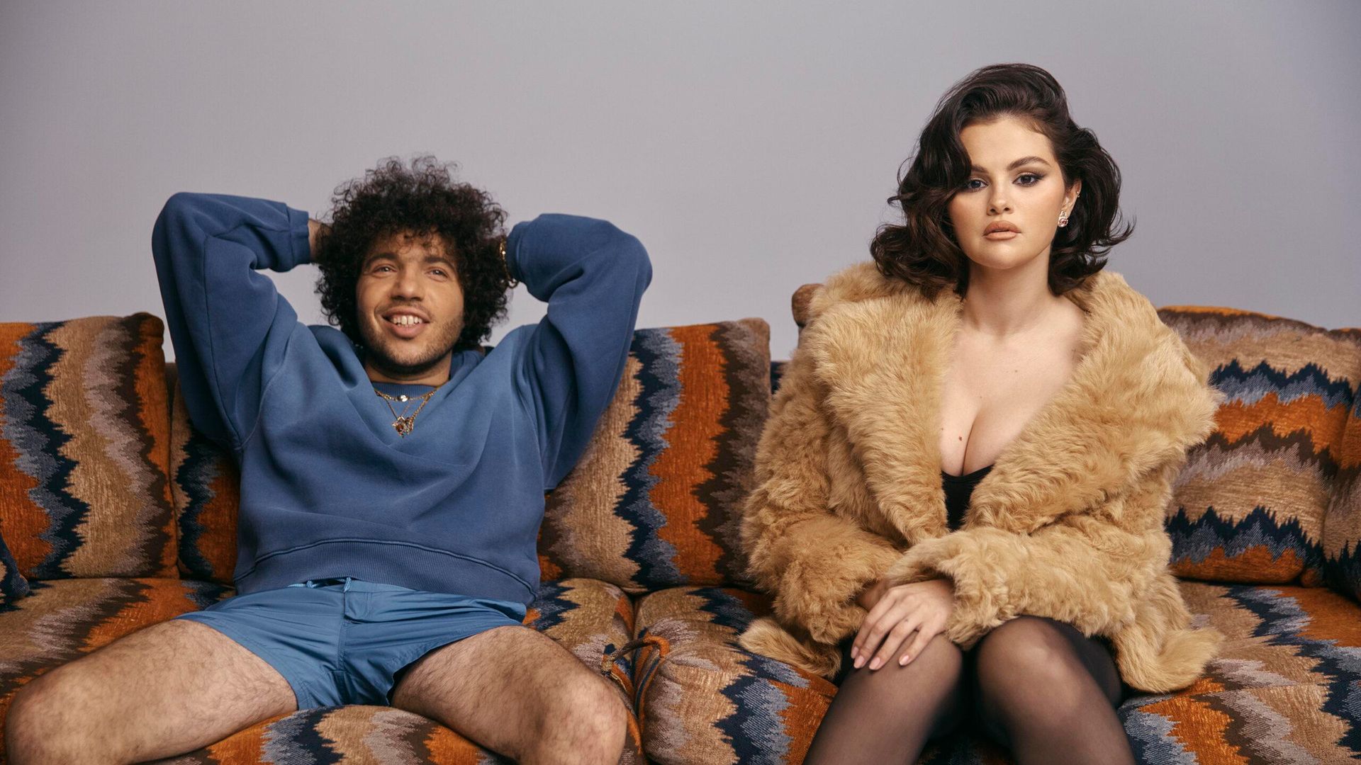 Selena Gomez w futrze i Benny Blanco w niebieskiej bluzie i szortach siedzą zrelaksowani