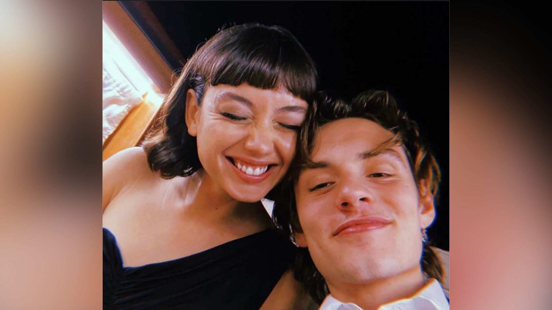 Śmiejąca się Sydney Chandler i uśmiechnięty Louis Partridge