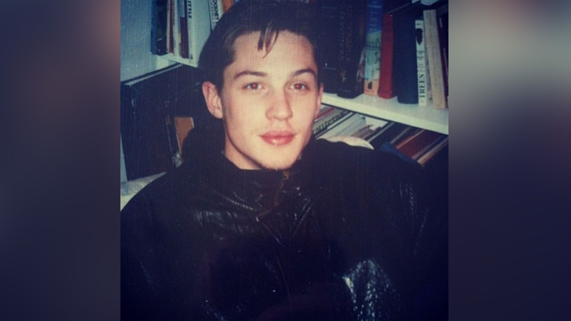 Młody Tom Hardy obok regału z książkami