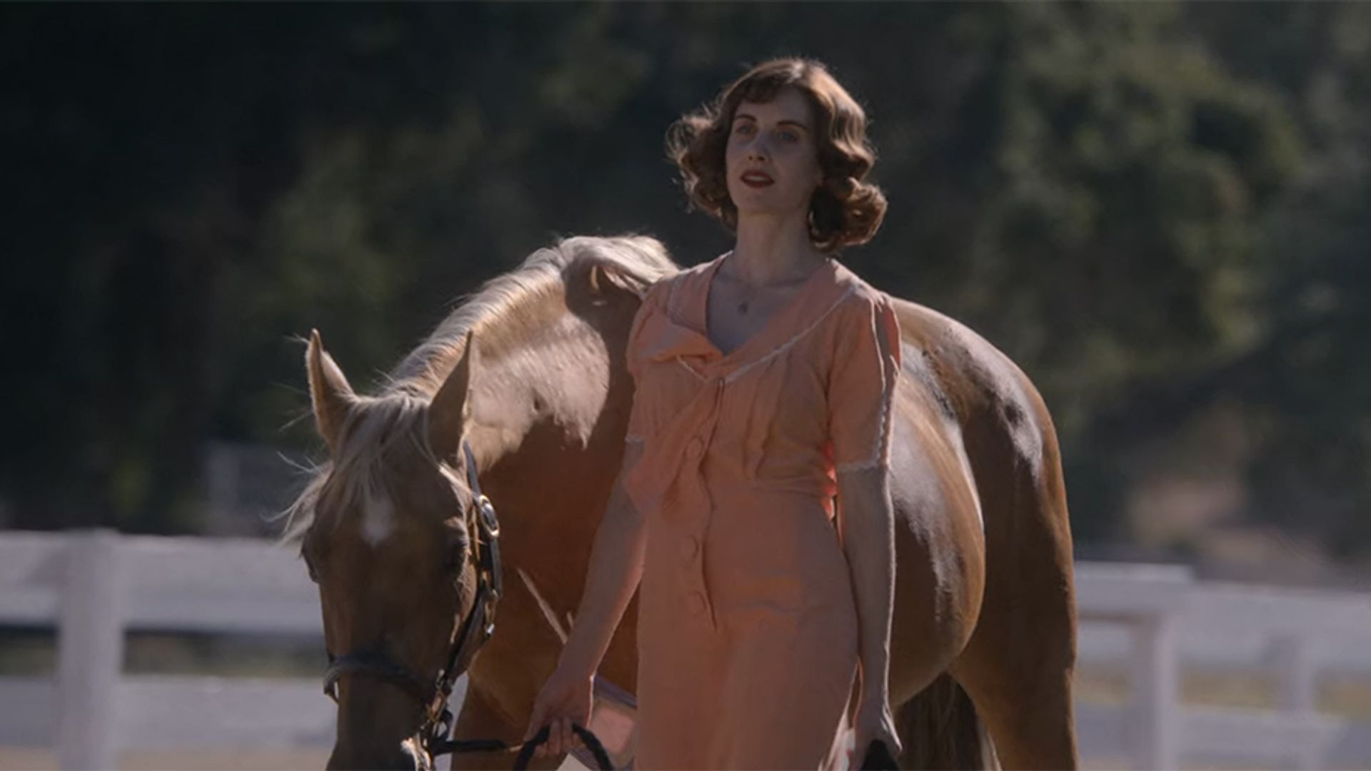 Alison Brie prowadząca konia za wodze, kadr z filmu "Horse Girl"