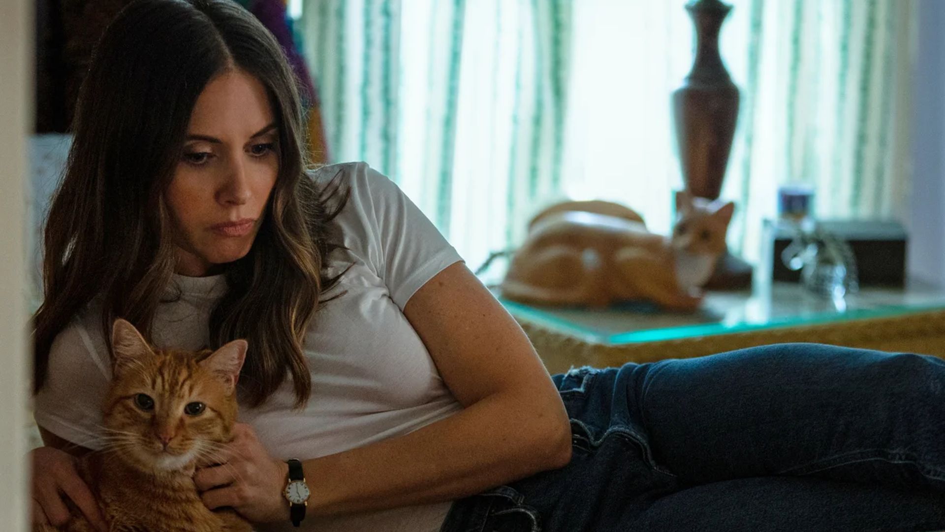 Alison Brie leży na łóżku z kotem w ramionach