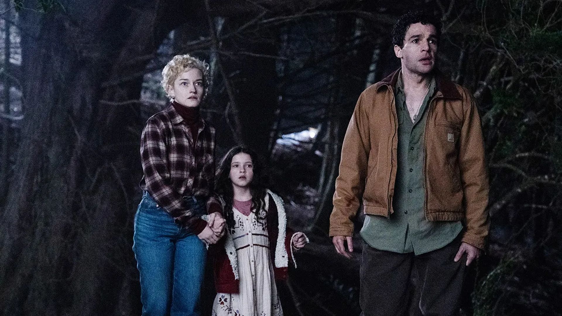 Julia Garner, Christopher Abbott i Matilda Firth w nocnym lesie, kadr z filmu "Wolf Man"