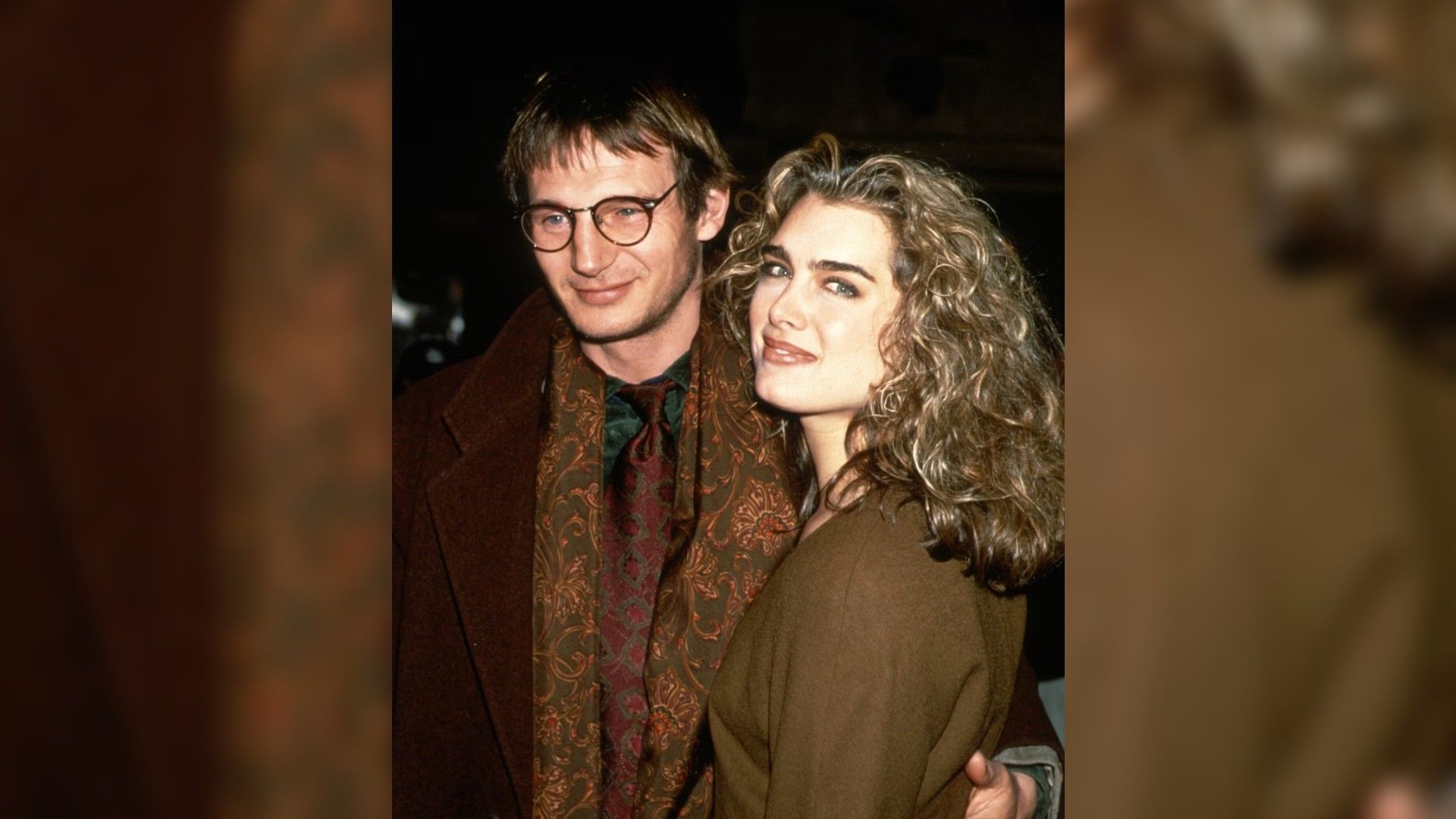 Liam Neeson i Brooke Shields w młodości, przytuleni idą do przodu