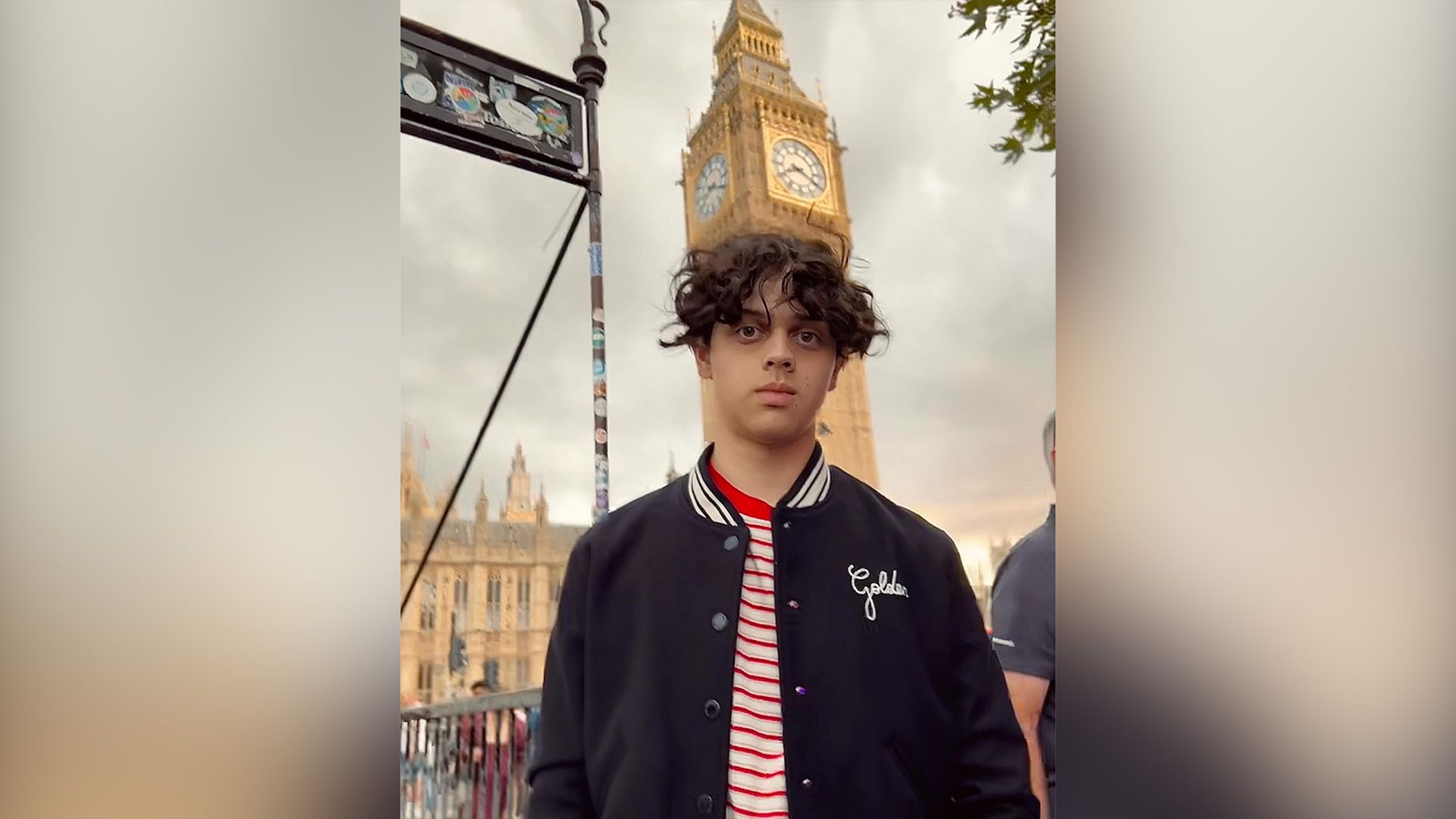 Isaac Ordonez w niebieskiej kurtce baseballowej na tle wieży zegarowej Big Ben w Londynie