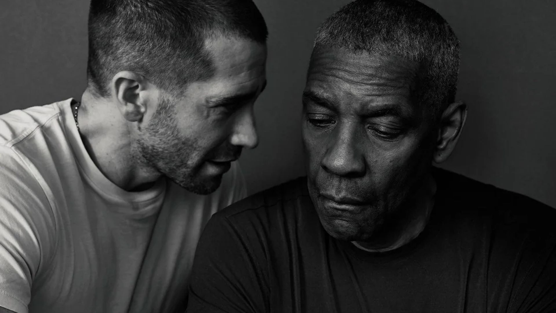 Jake Gyllenhaal i Denzel Washington na czarno-białym portrecie: jeden mówi, podczas gdy drugi spogląda w dół z zamyślonym wyrazem twarzy